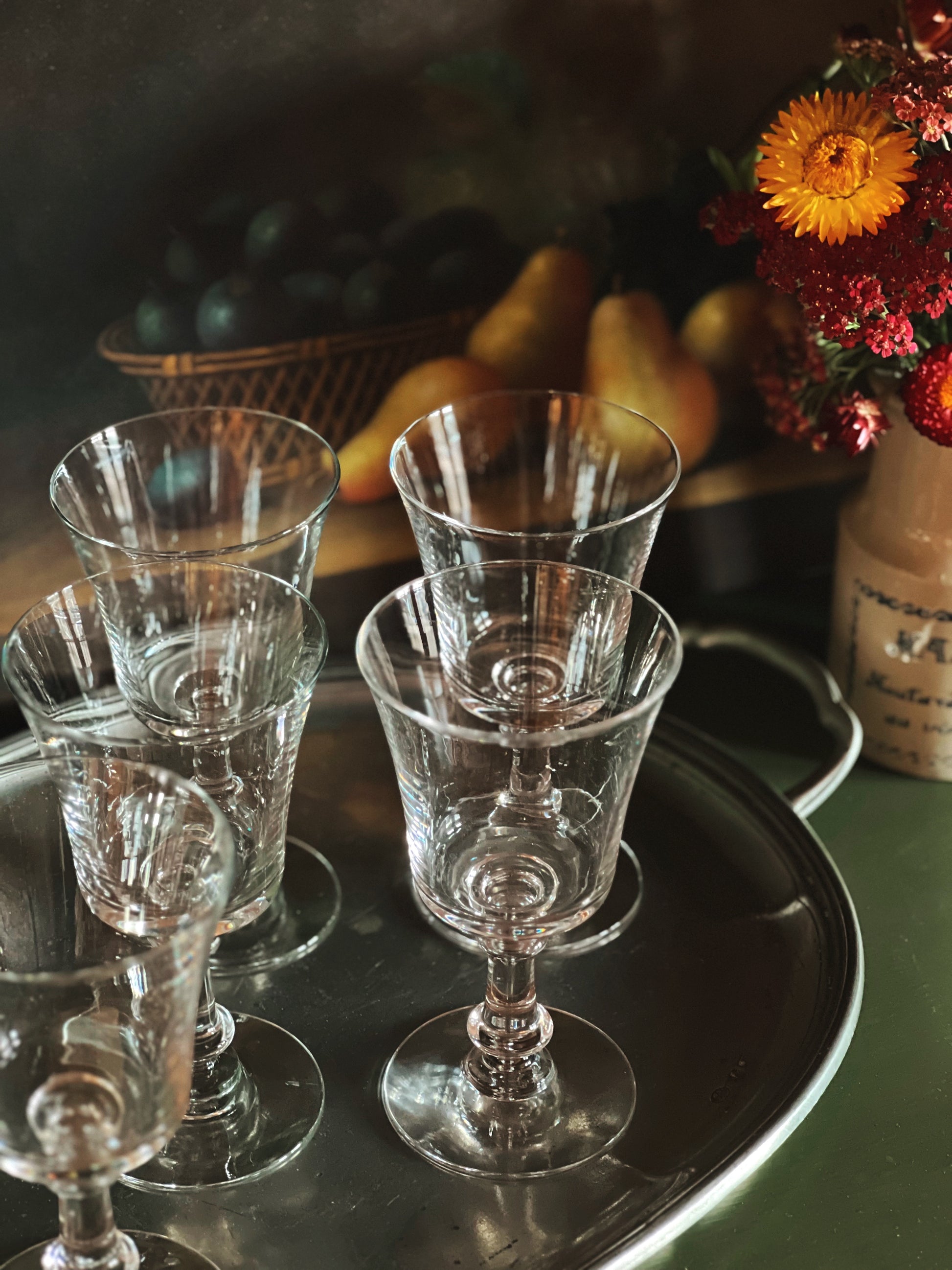 Set of clear glass goblets on a dark tray with a blurred background