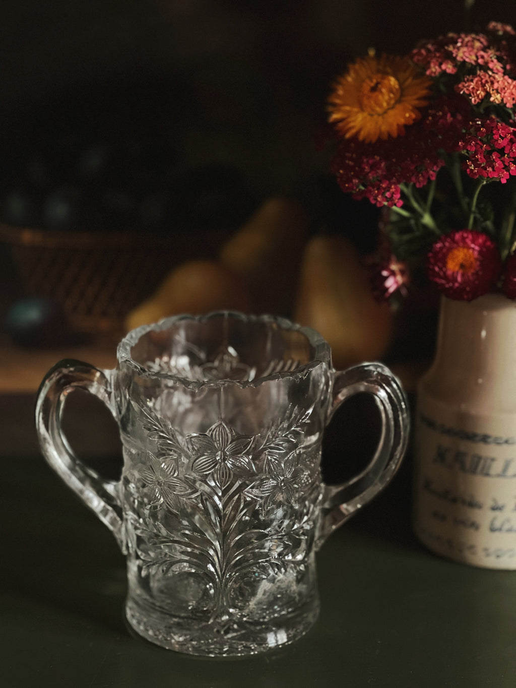 Decorative glass mug with floral patterns on a dark background