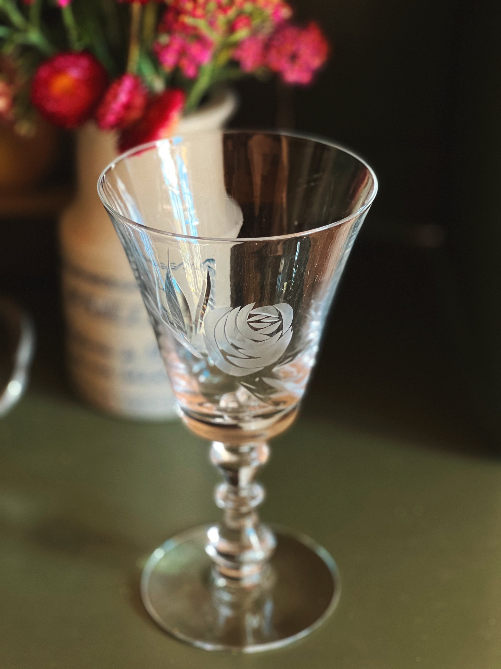 Clear glass goblet with floral design on a dark background