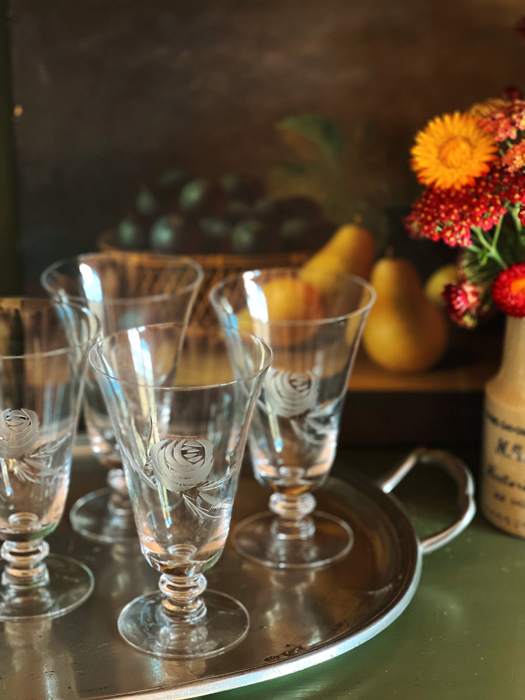 Set of glass goblets on a tray with a decorative background