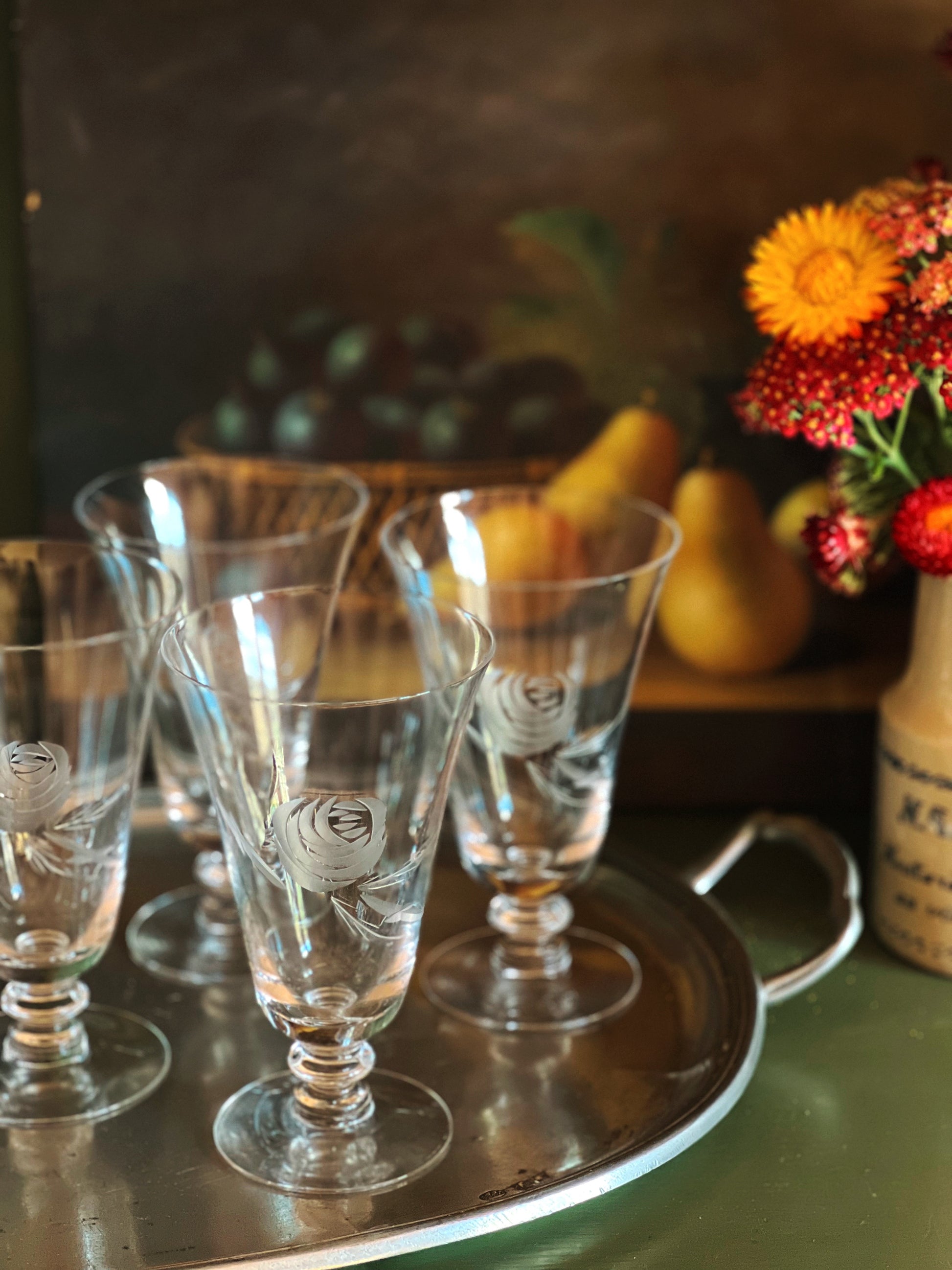Set of glass goblets on a tray with a decorative background
