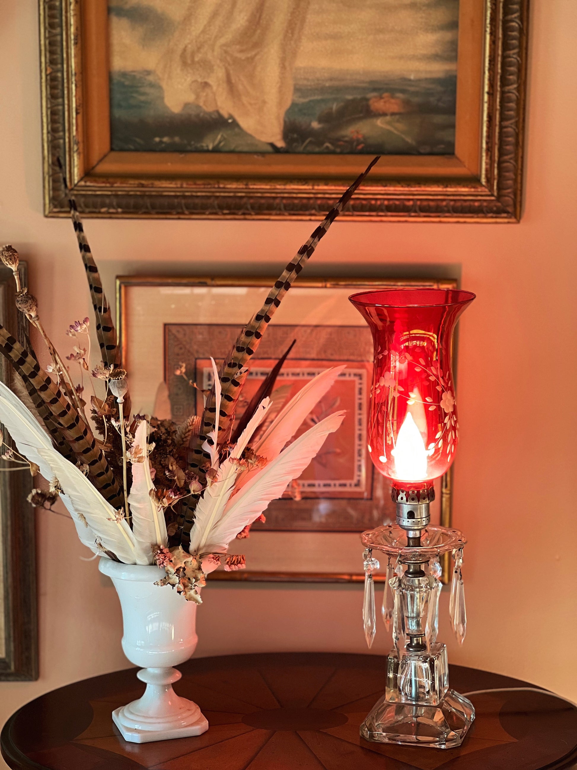 cranberry and crystal lamp on a table next to a dried floral arrangement