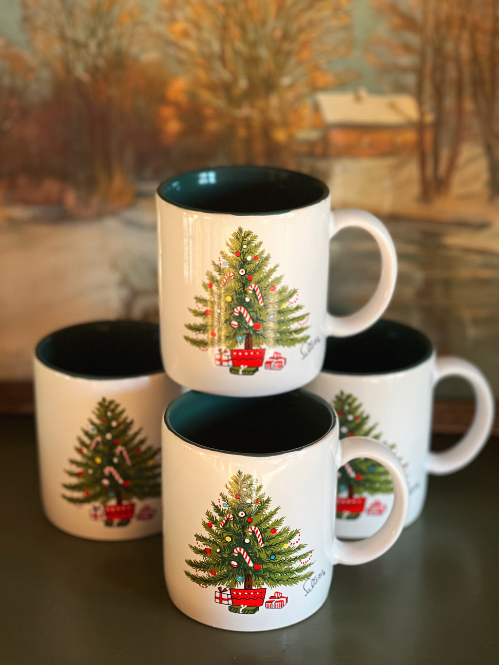 Set of mugs with Christmas tree design on a reflective surface