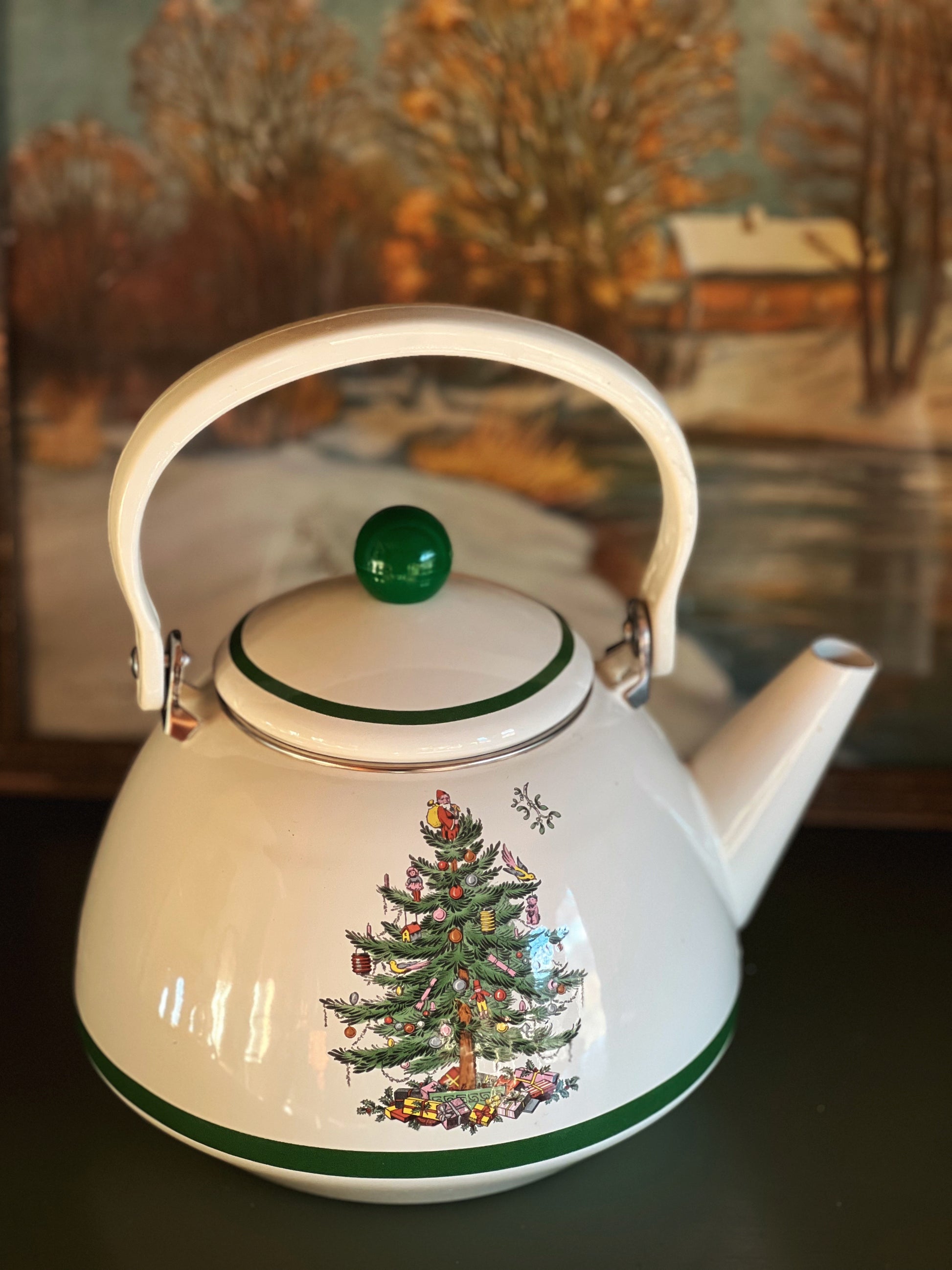 White teapot with Christmas tree design on a dark surface