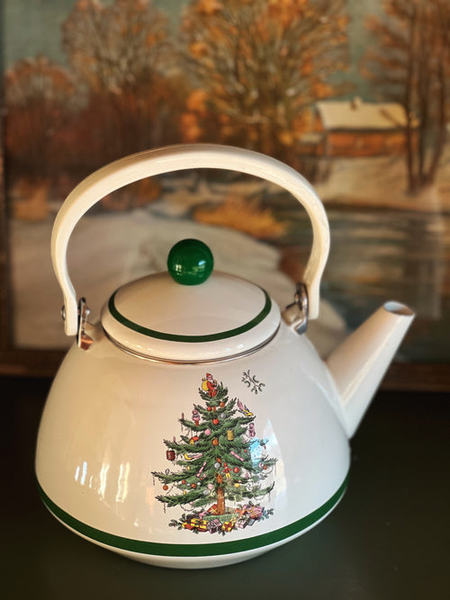 White teapot with Christmas tree design on a dark surface