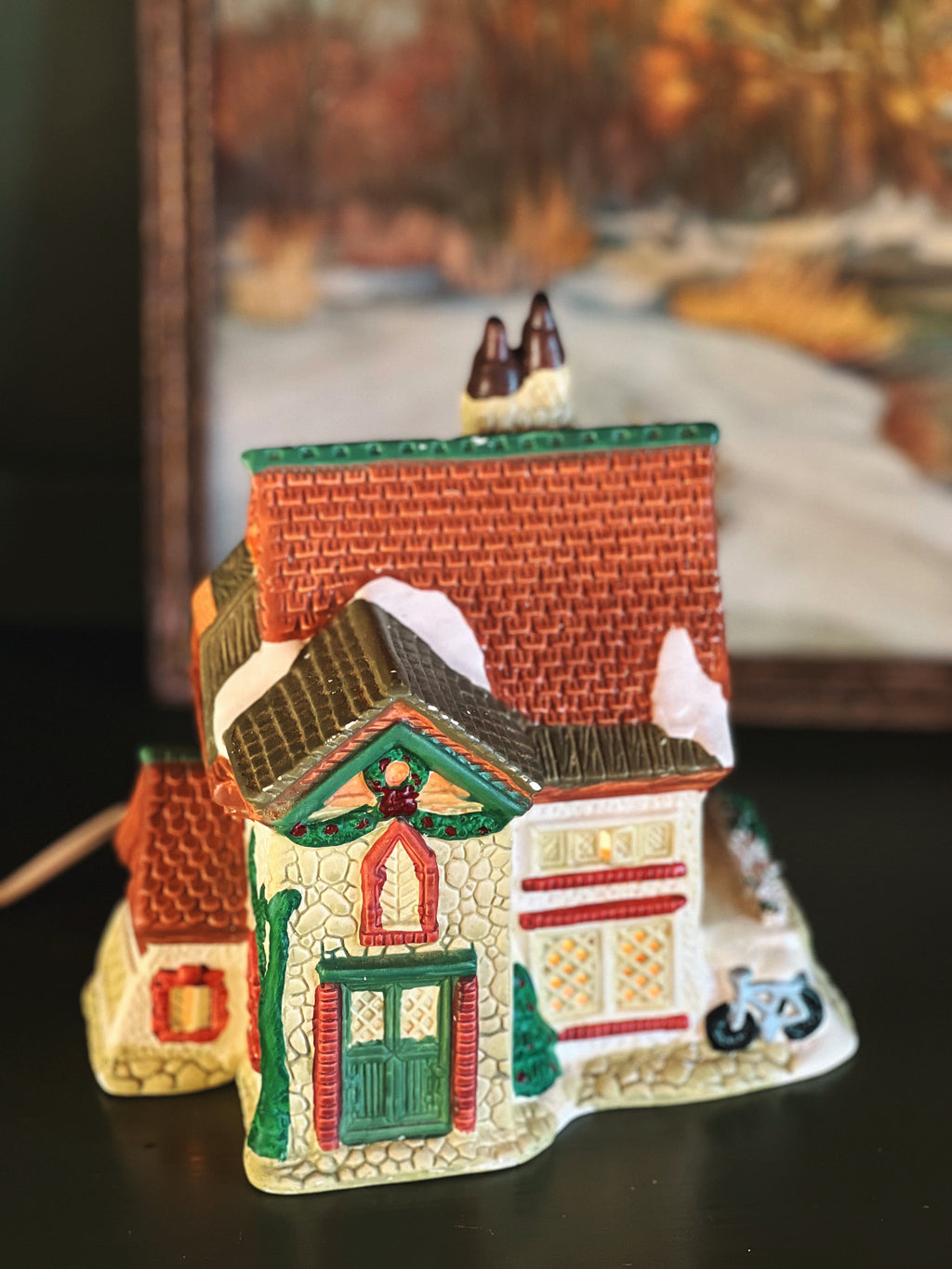 light up Christmas village house with a brown roof and green front door