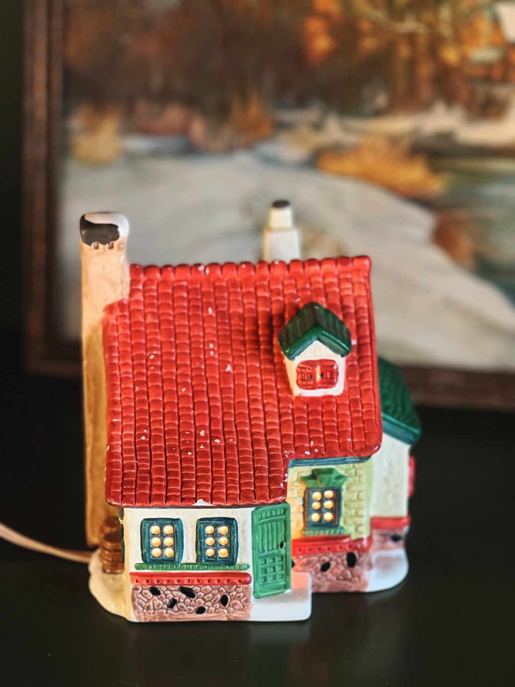 light up Christmas village cottage with a red roof and green front door