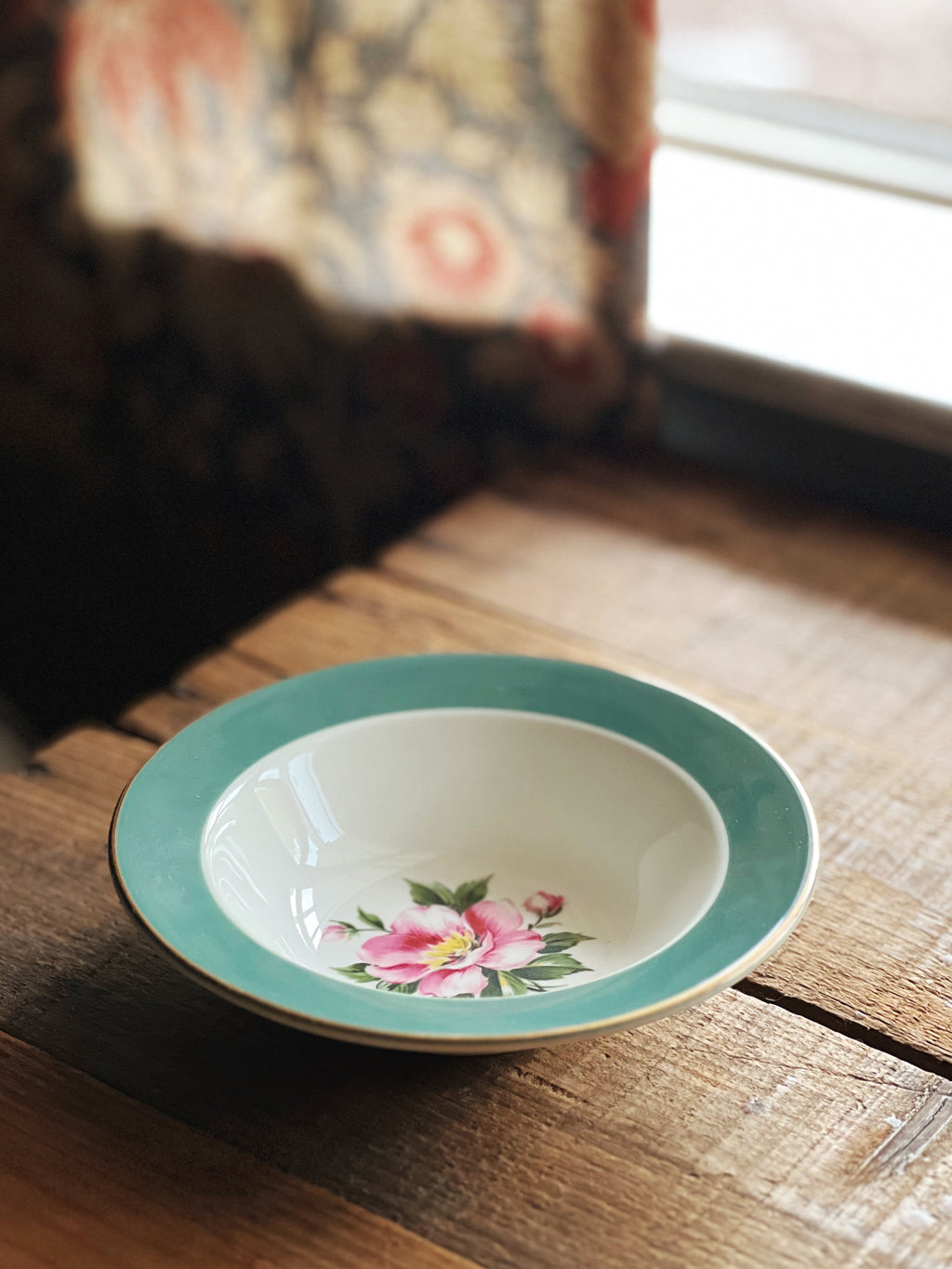 Ceramic bowl with floral design on a wooden surface