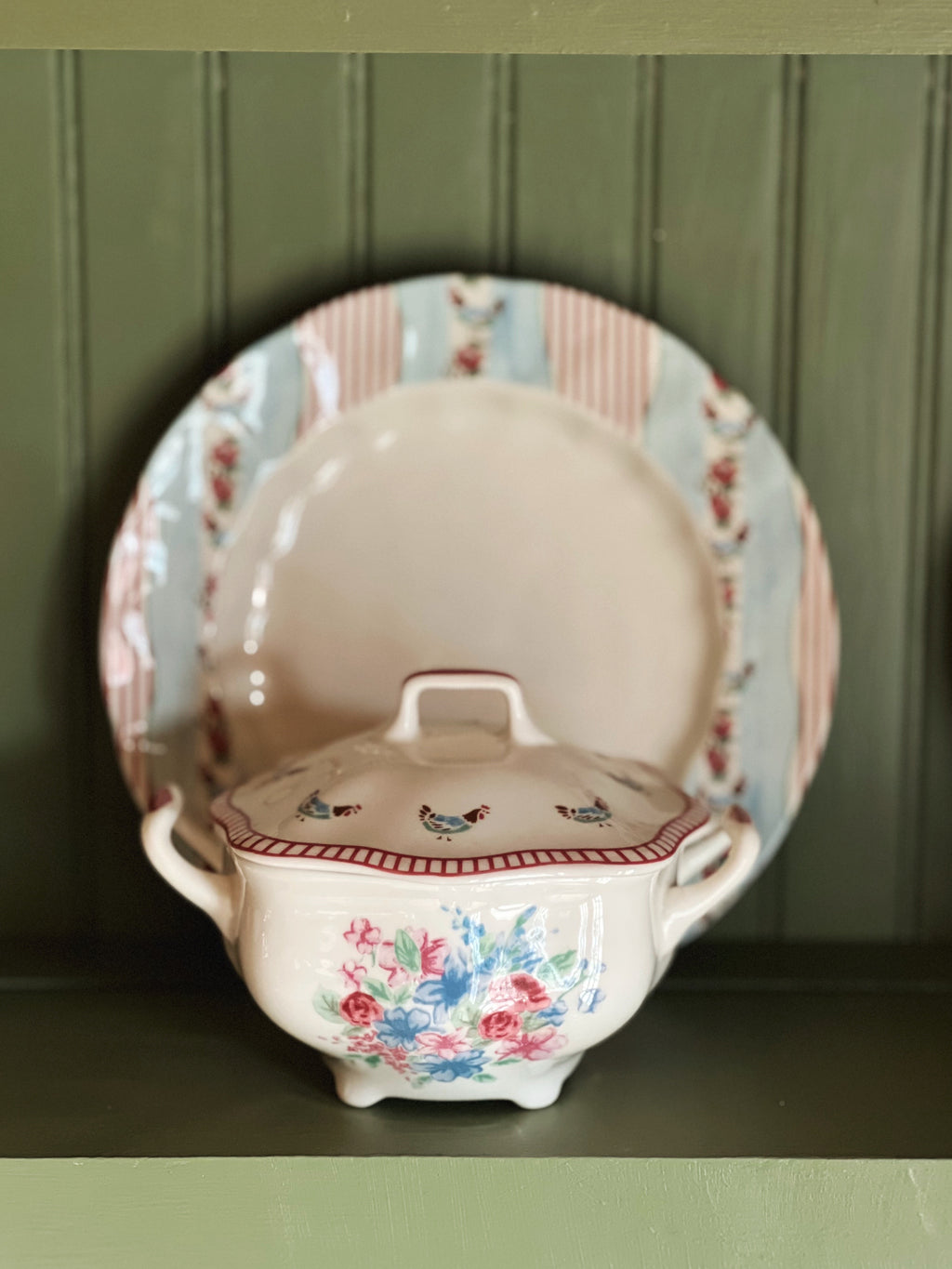 Ceramic tureen with floral design on a green background