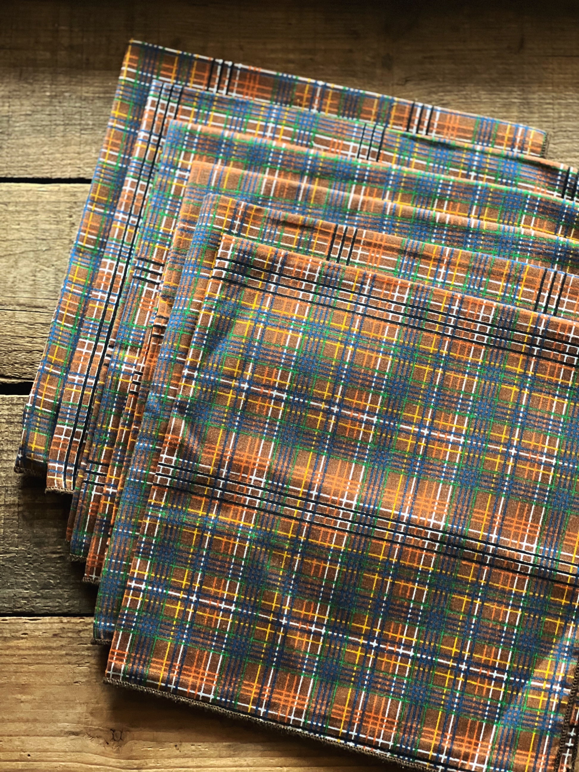 Plaid fabric napkins on a wooden surface