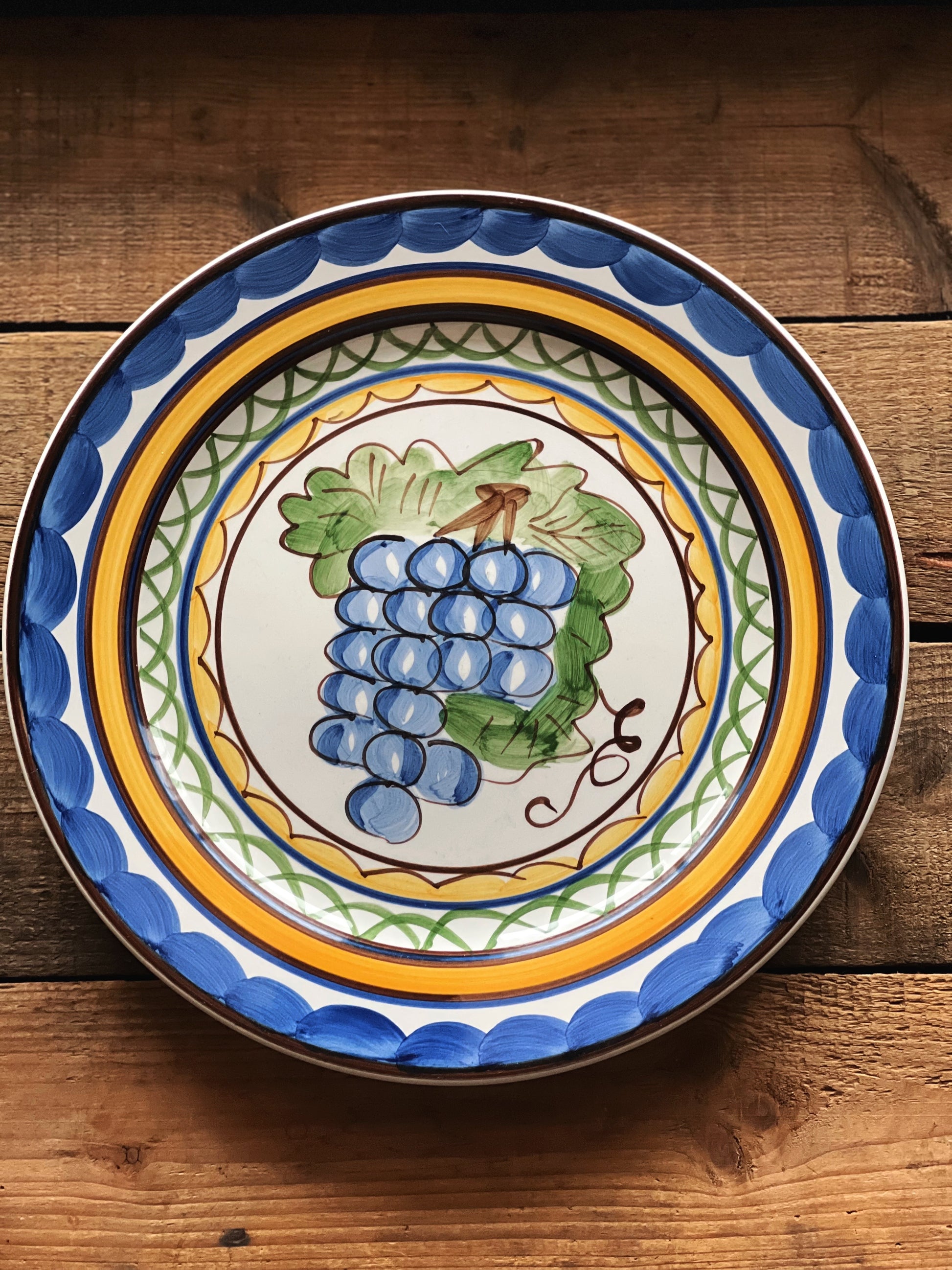 dinner plate with a hand painted design and grapevine pattern