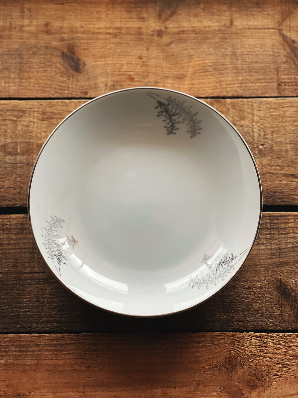 White ceramic plate with decorative edge on a wooden surface