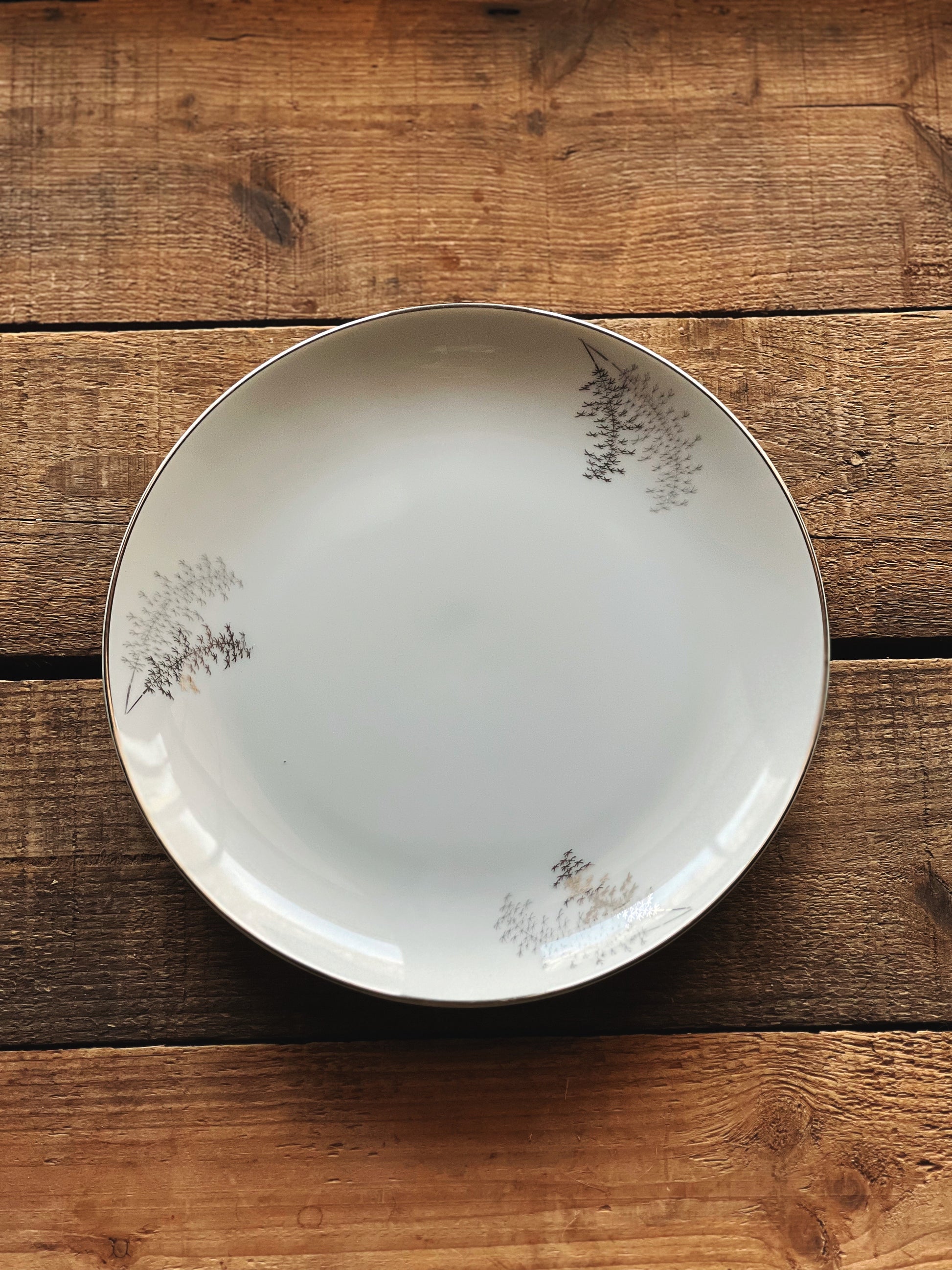 White ceramic plate with floral patterns on a wooden surface