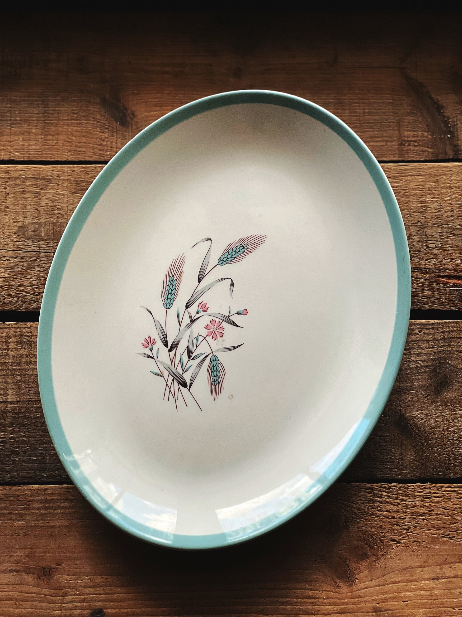 Decorative ceramic plate with floral design on a wooden surface