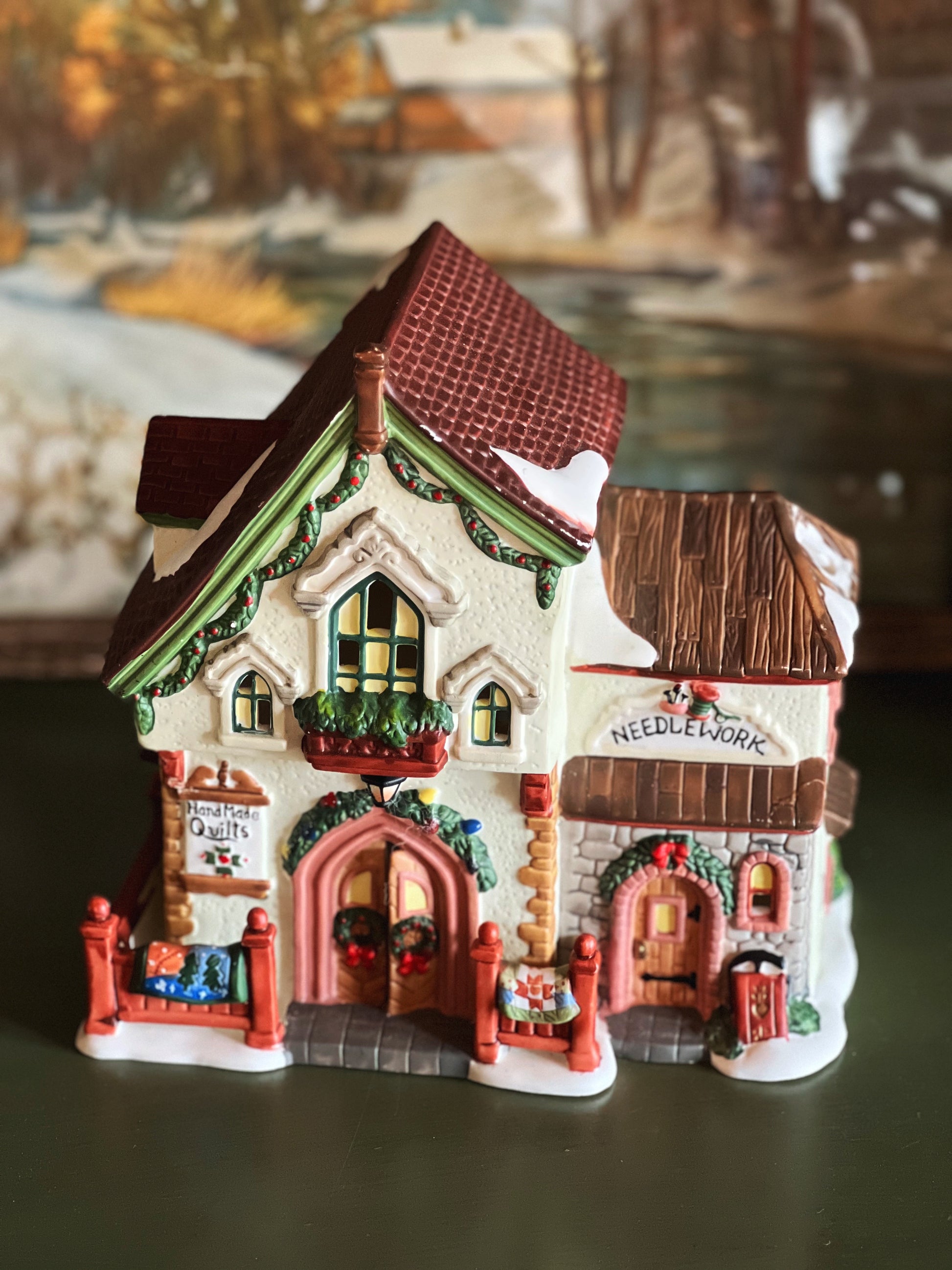 Decorative miniature village houses with detailed facades on a reflective surface.