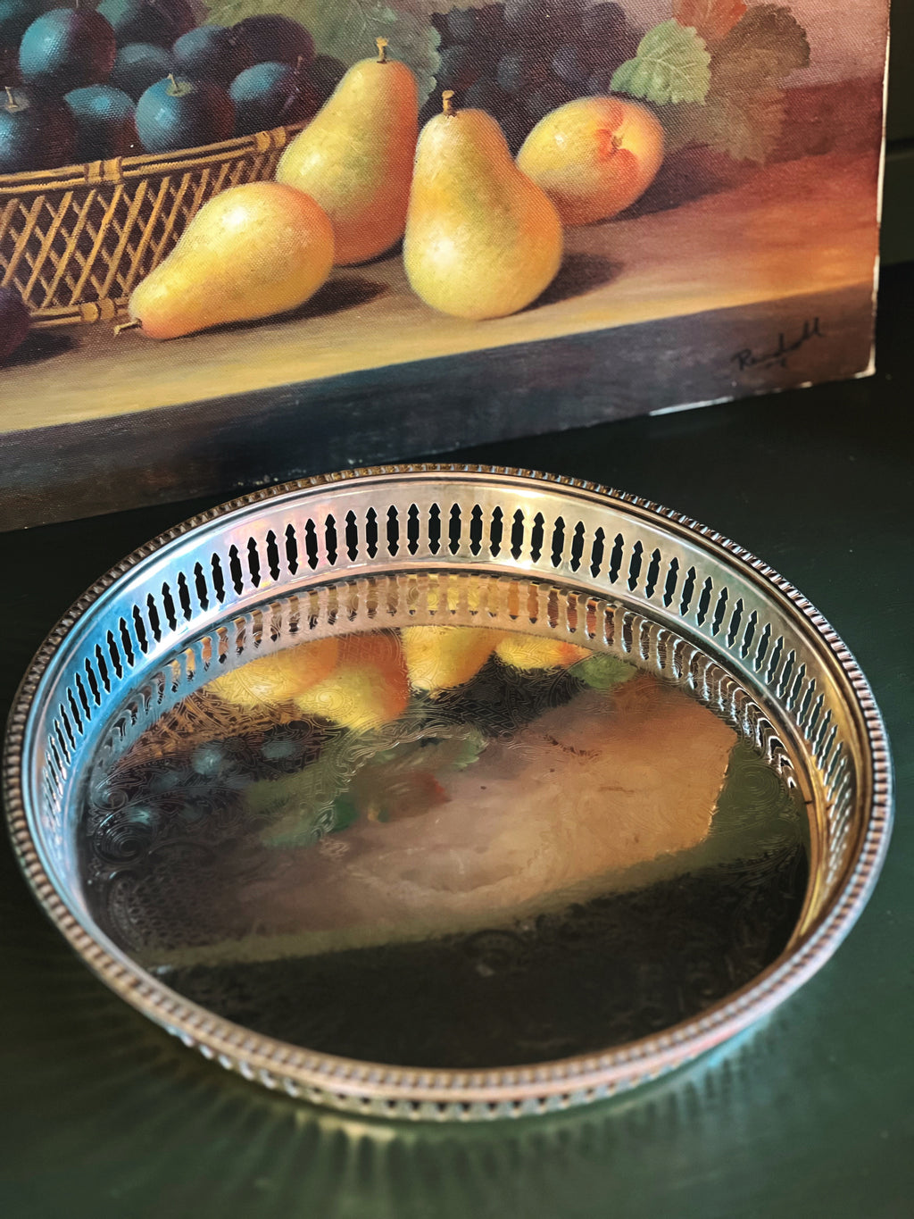 Decorative tray with a reflection of a painting of pears and plums.