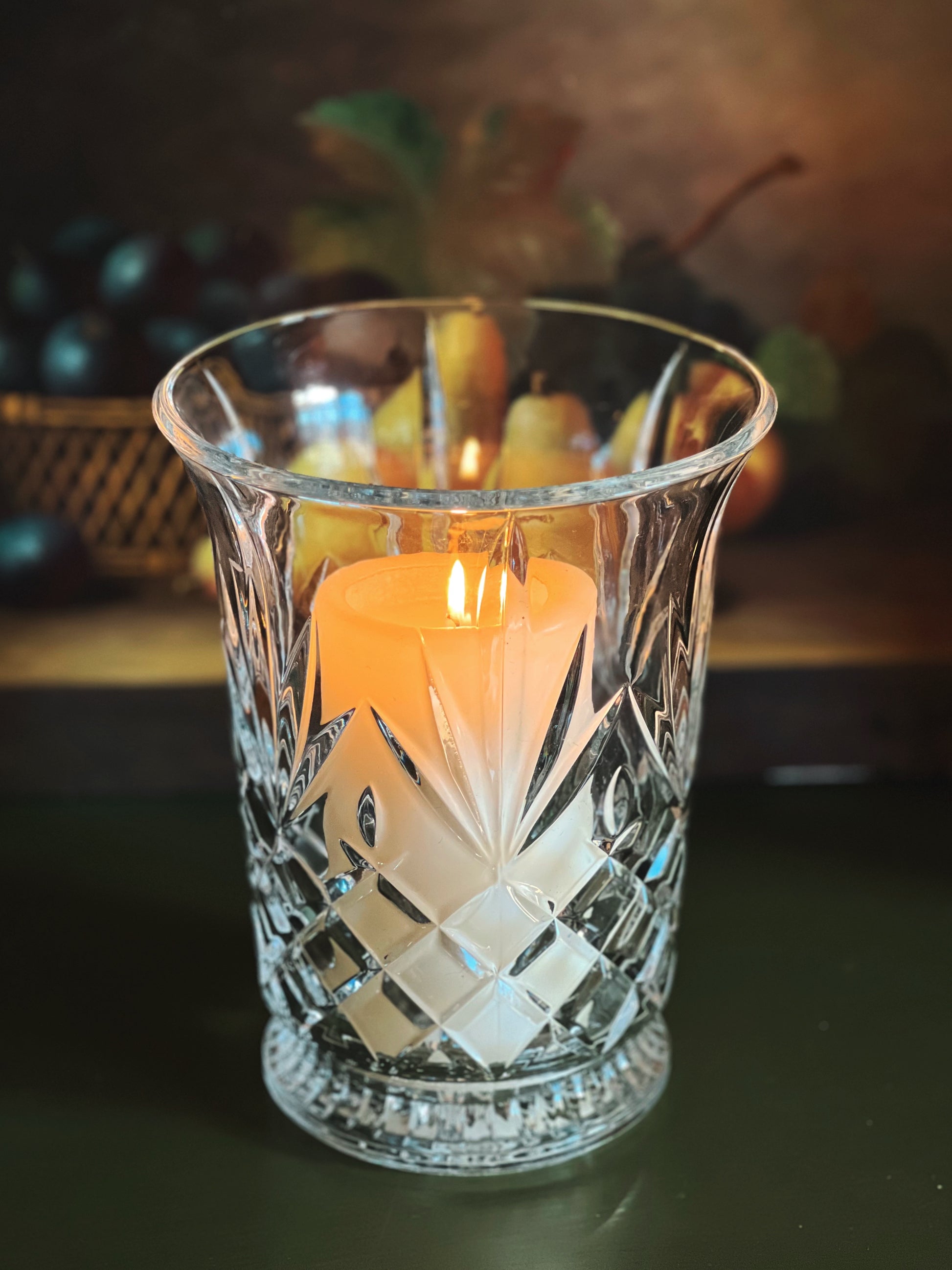 Candle in a decorative glass holder with a blurred background
