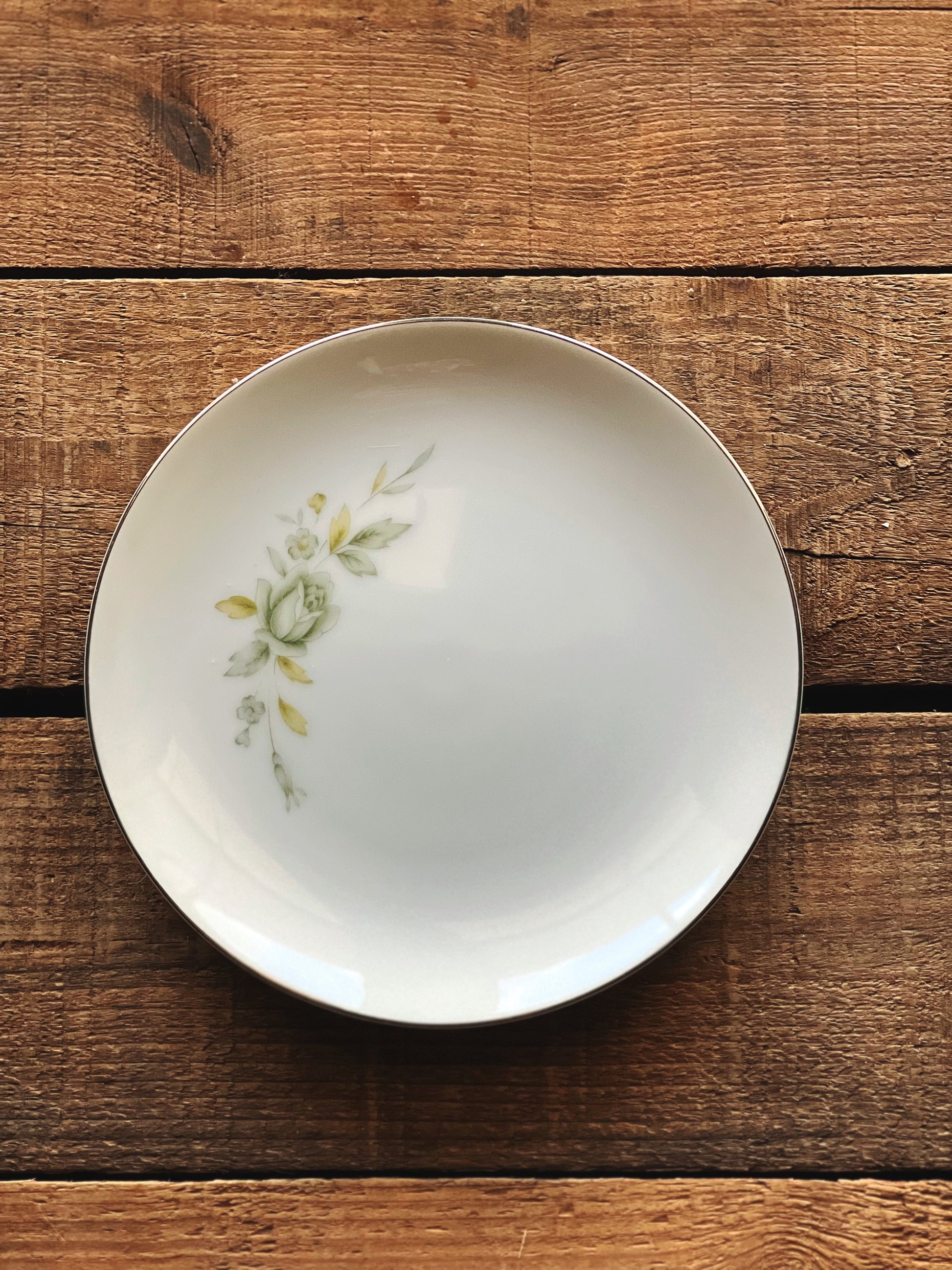 White ceramic bowl with floral design on a wooden surface