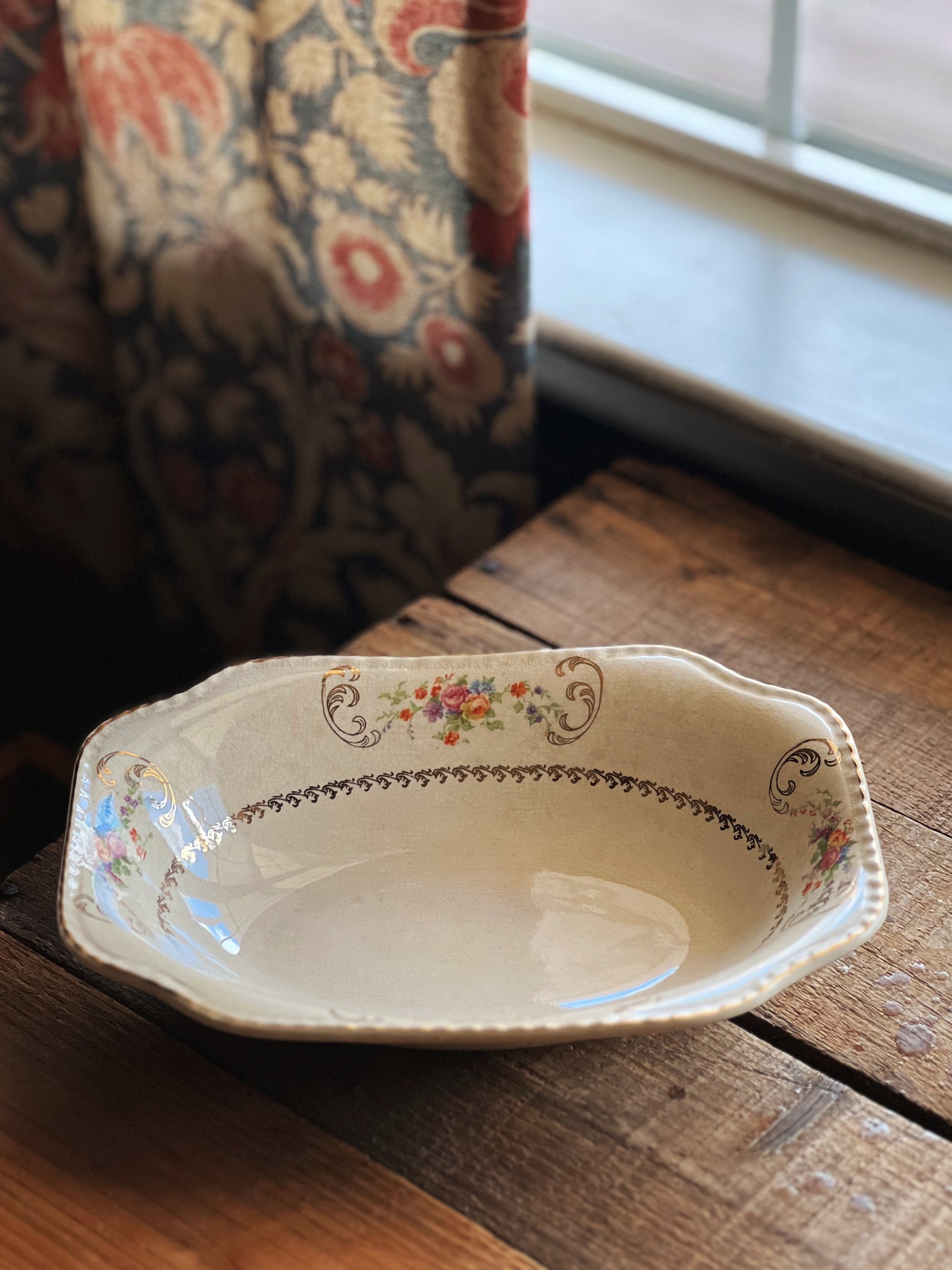 Decorative ceramic dish on a wooden surface with a floral pattern