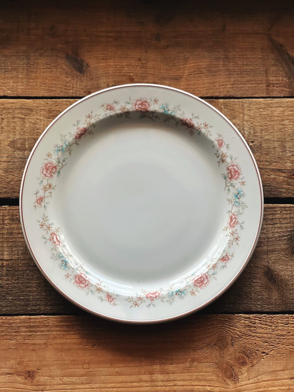 Decorative plate with floral rim on a wooden surface