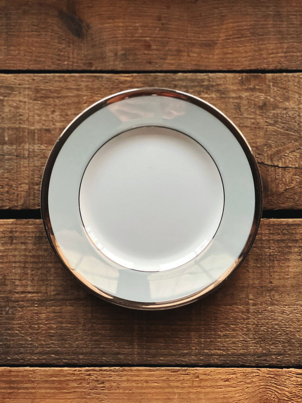 White plate with gold rim on a wooden surface