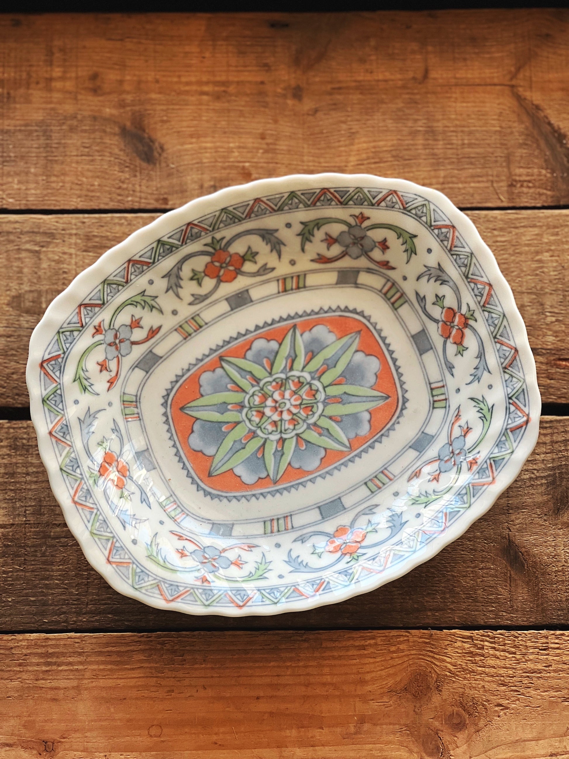 Decorative ceramic plate with floral patterns on a wooden surface
