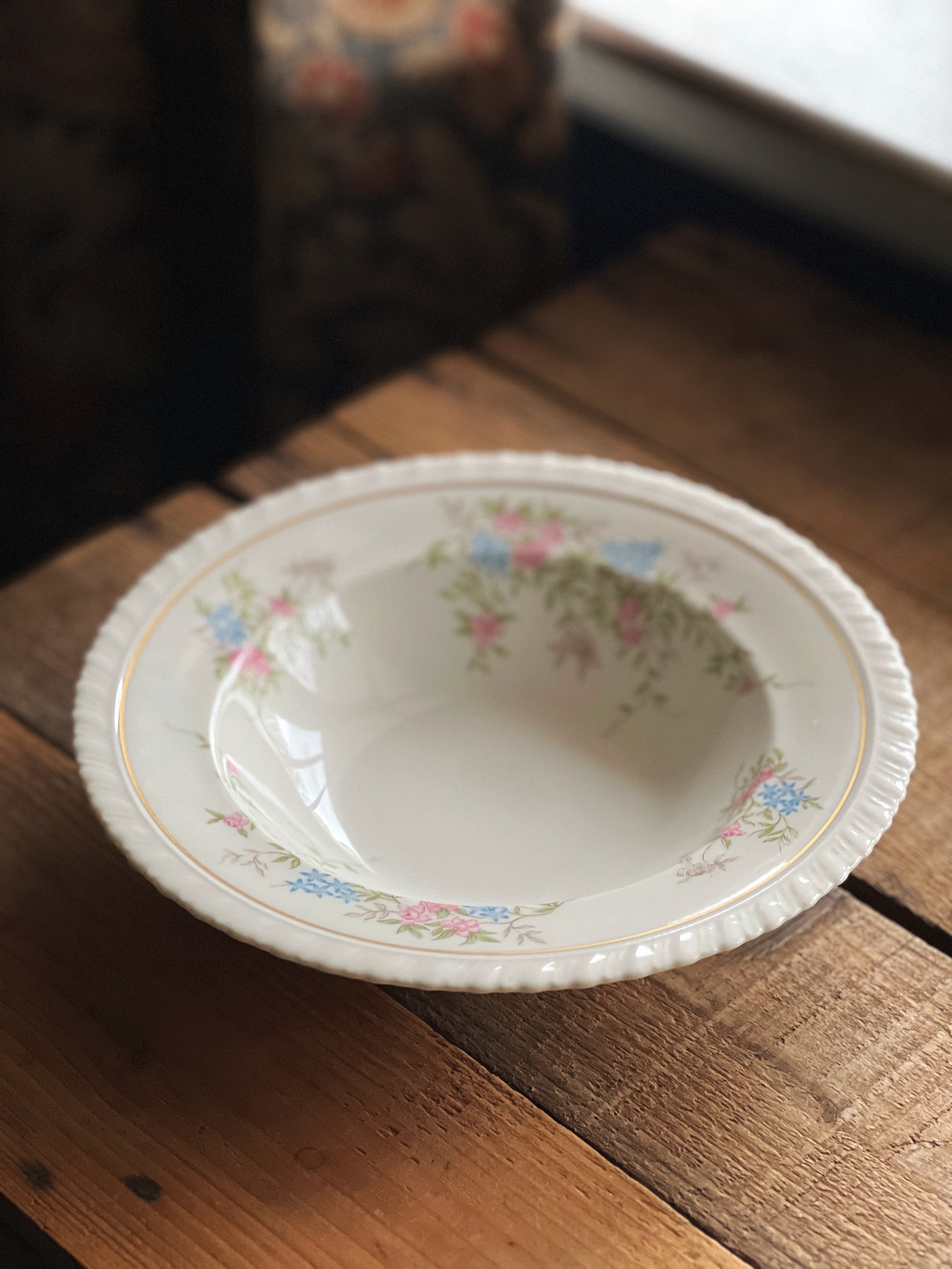 Decorative ceramic plate with floral patterns on a wooden surface