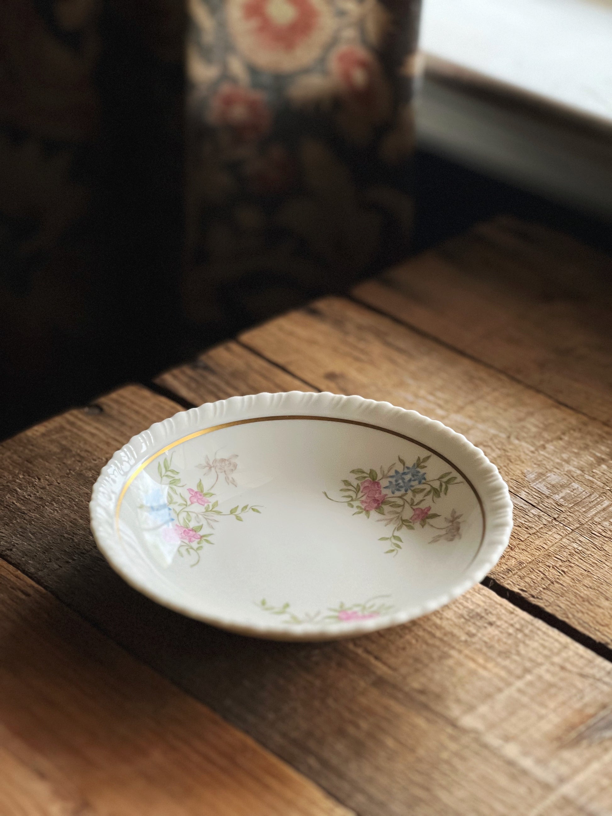 Small decorative bowl with floral patterns on a wooden surface