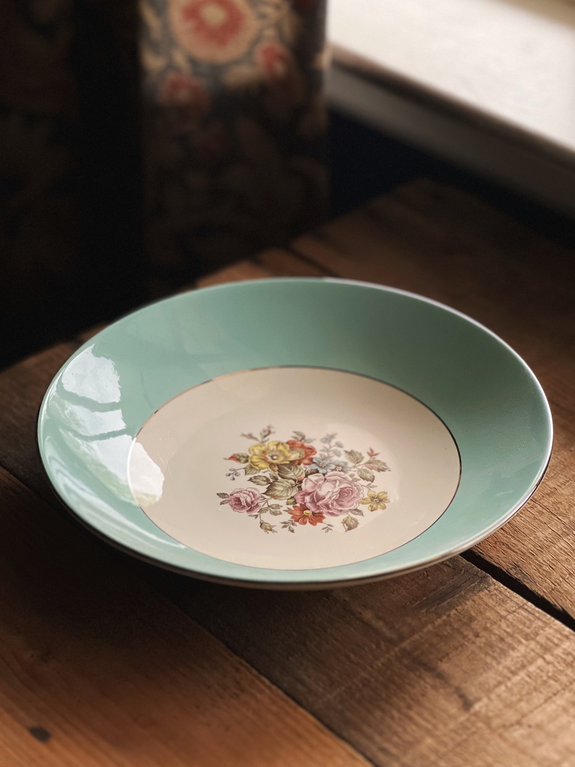 Decorative plate with floral design on a wooden surface