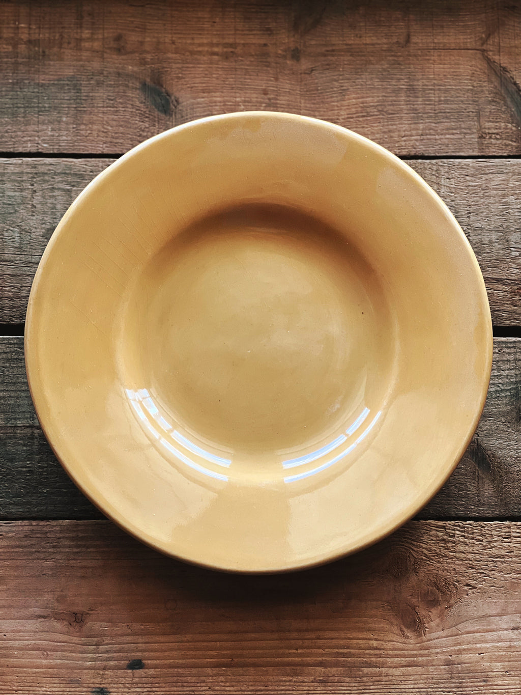Yellow ceramic bowl on a wooden surface
