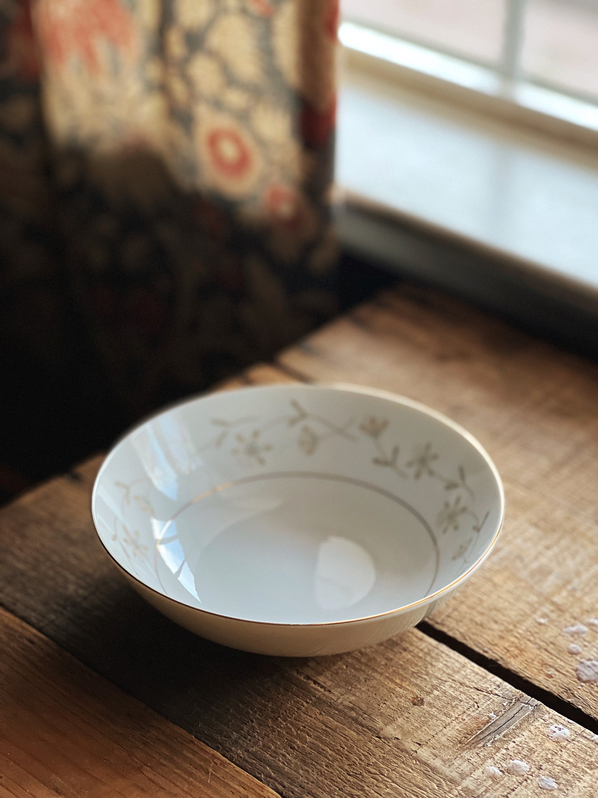 White ceramic bowl with floral patterns on a wooden surface