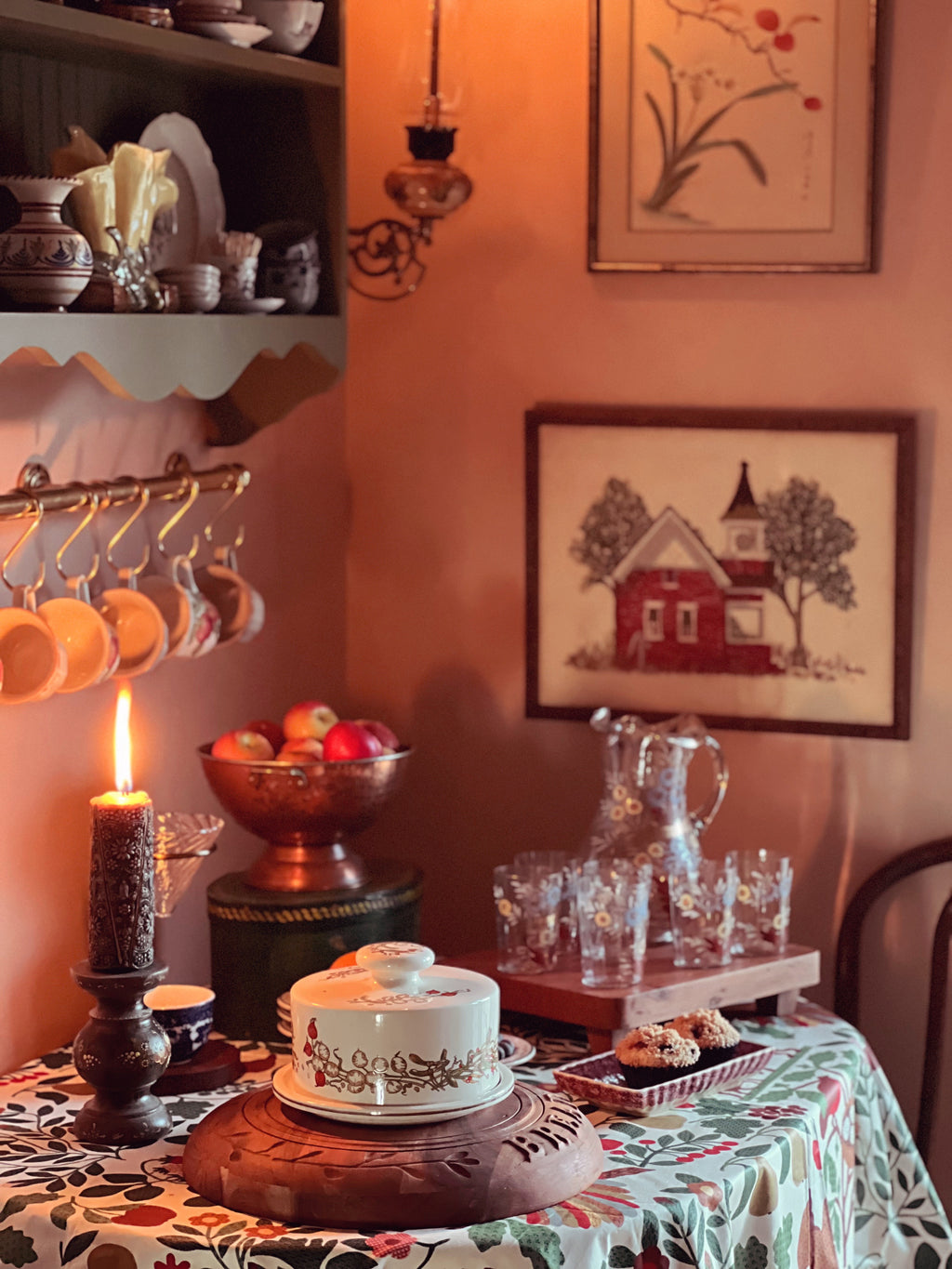 Dining room with a table set for a meal, including a cake, candles, and fruit bowl.