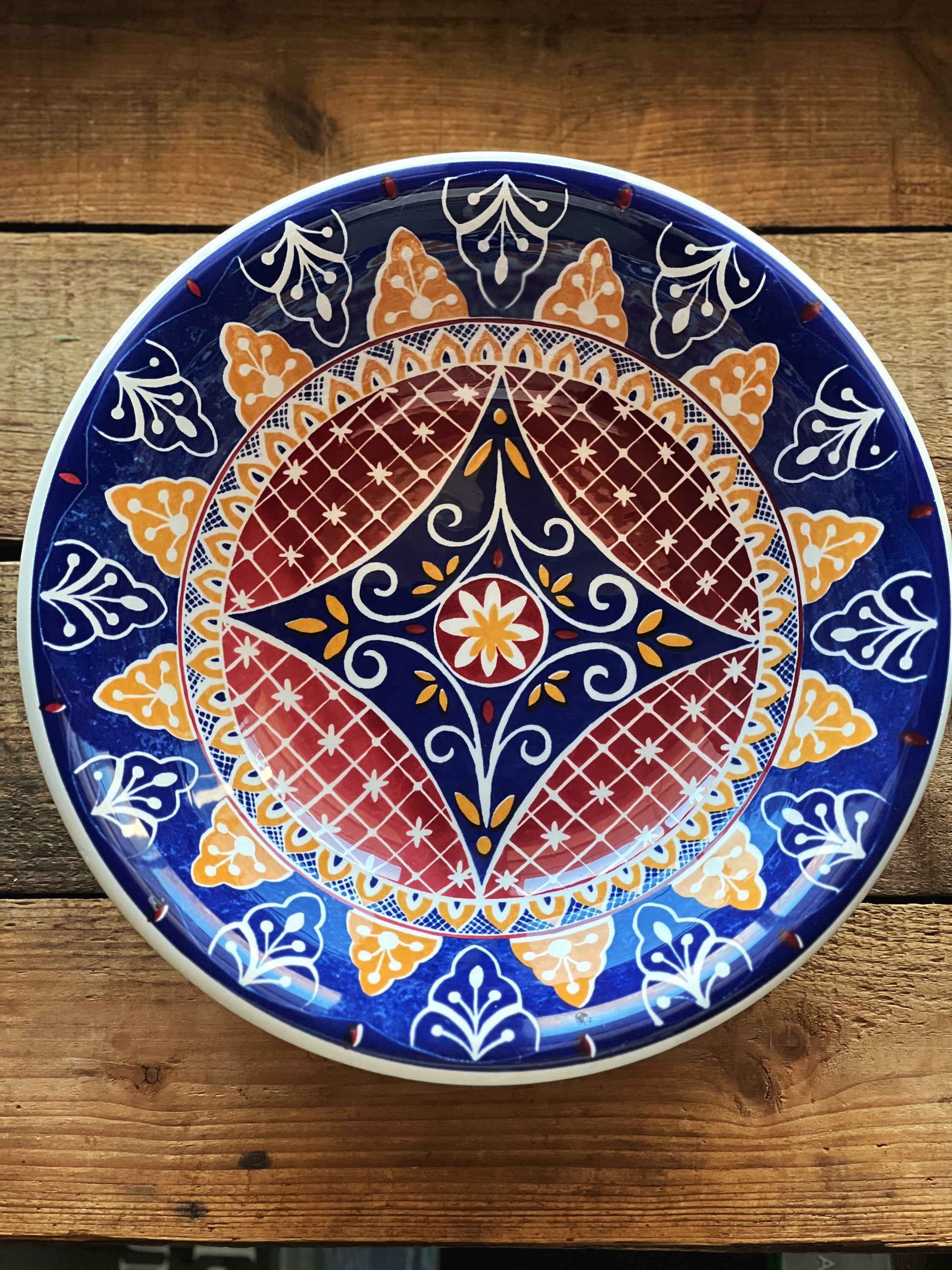 Decorative plate with intricate patterns on a wooden surface