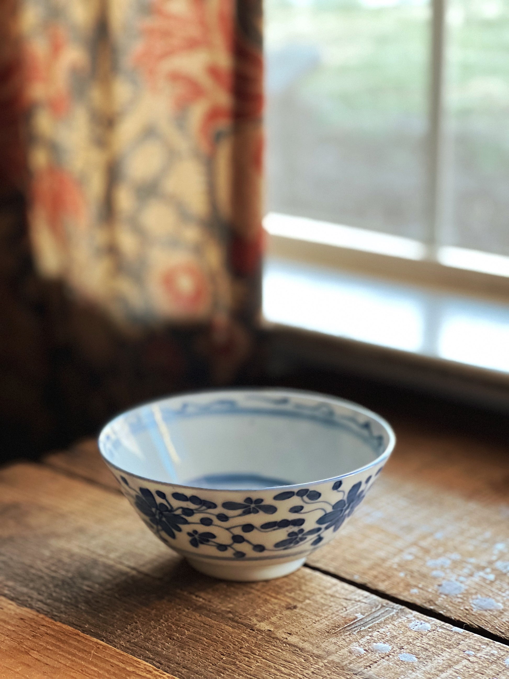 blue and white floral rice bowl on a wooden table