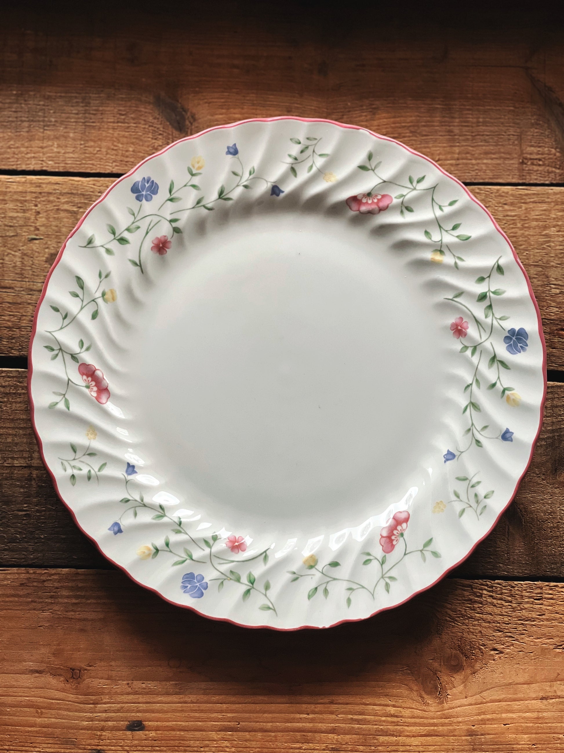 Decorative ceramic plate with floral patterns on a wooden surface