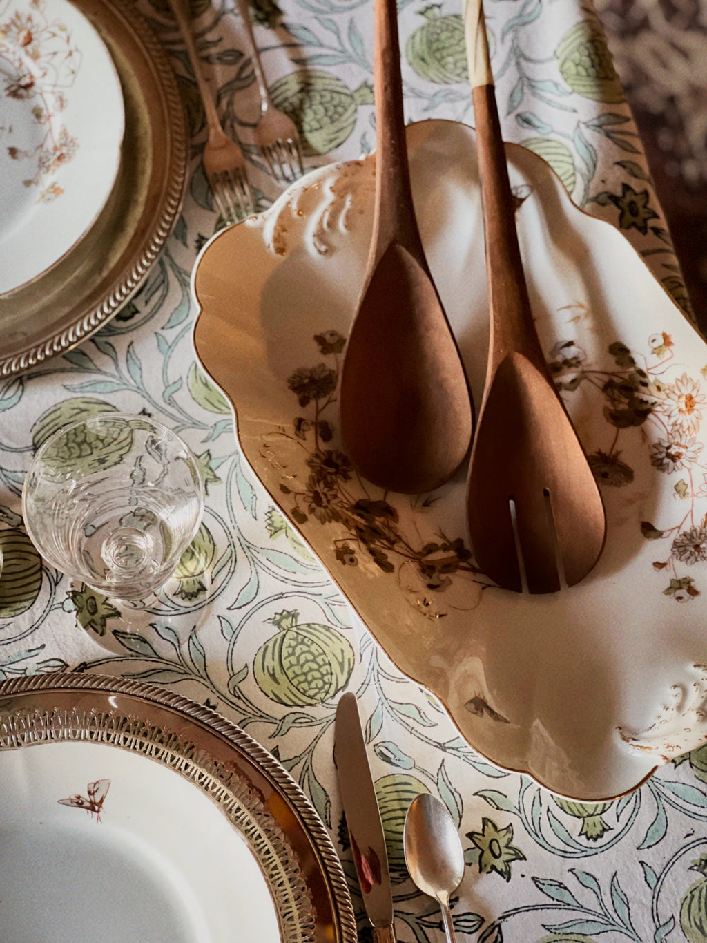 large antique platter on a table with wooden salad servers