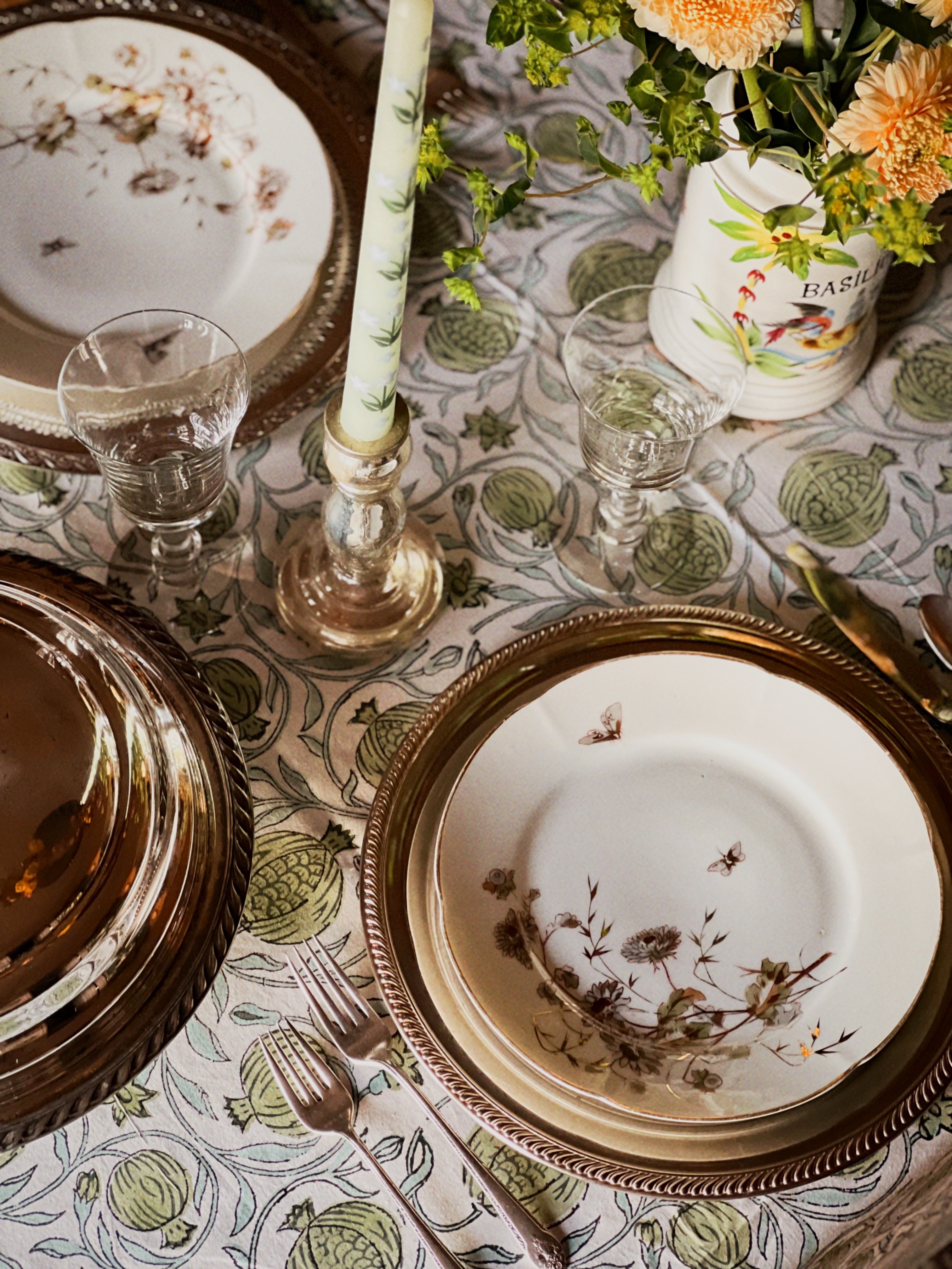 silver tray under a dinner plate on a table set for a meal