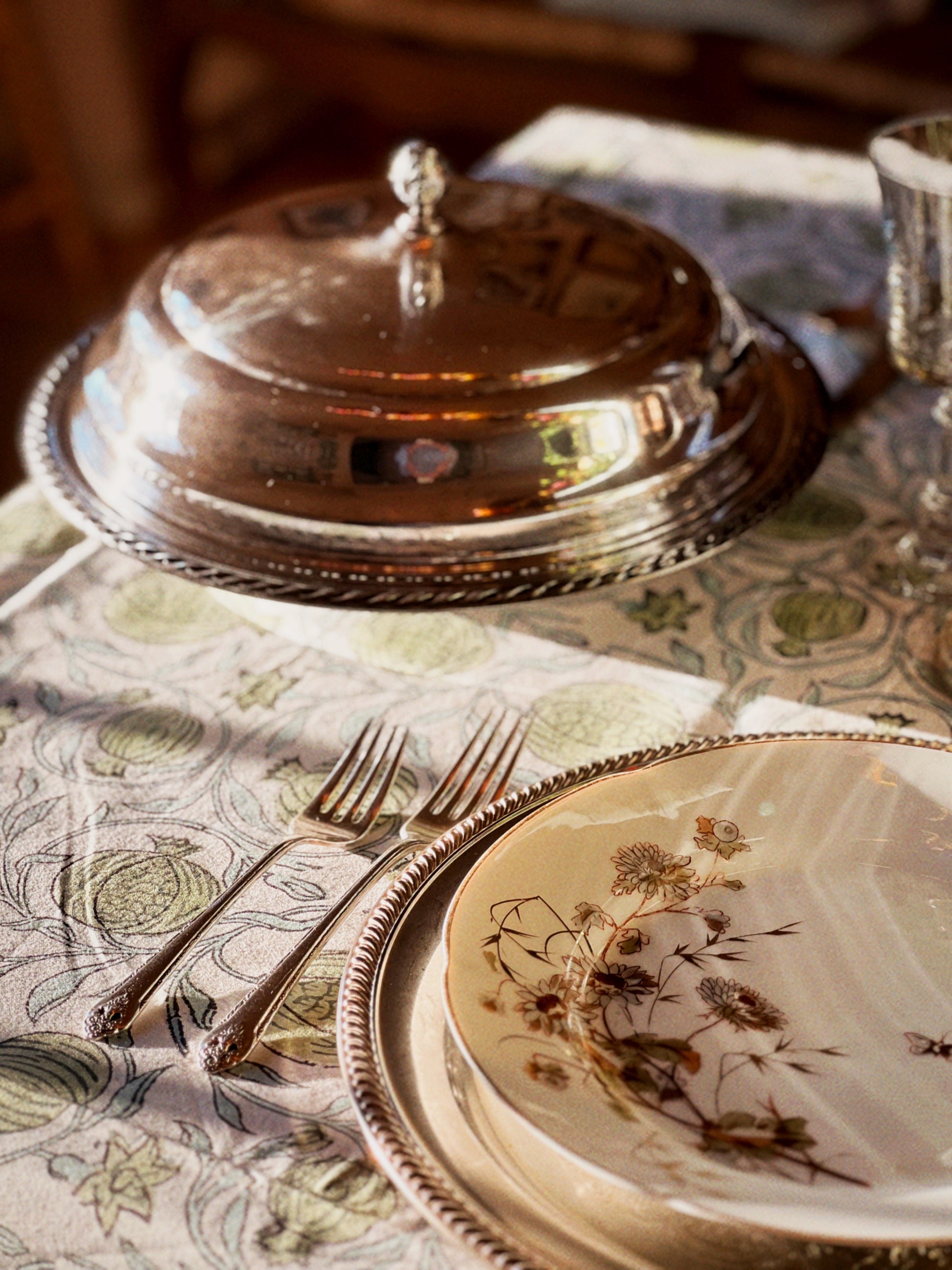 silver serving dish on a table set for a meal