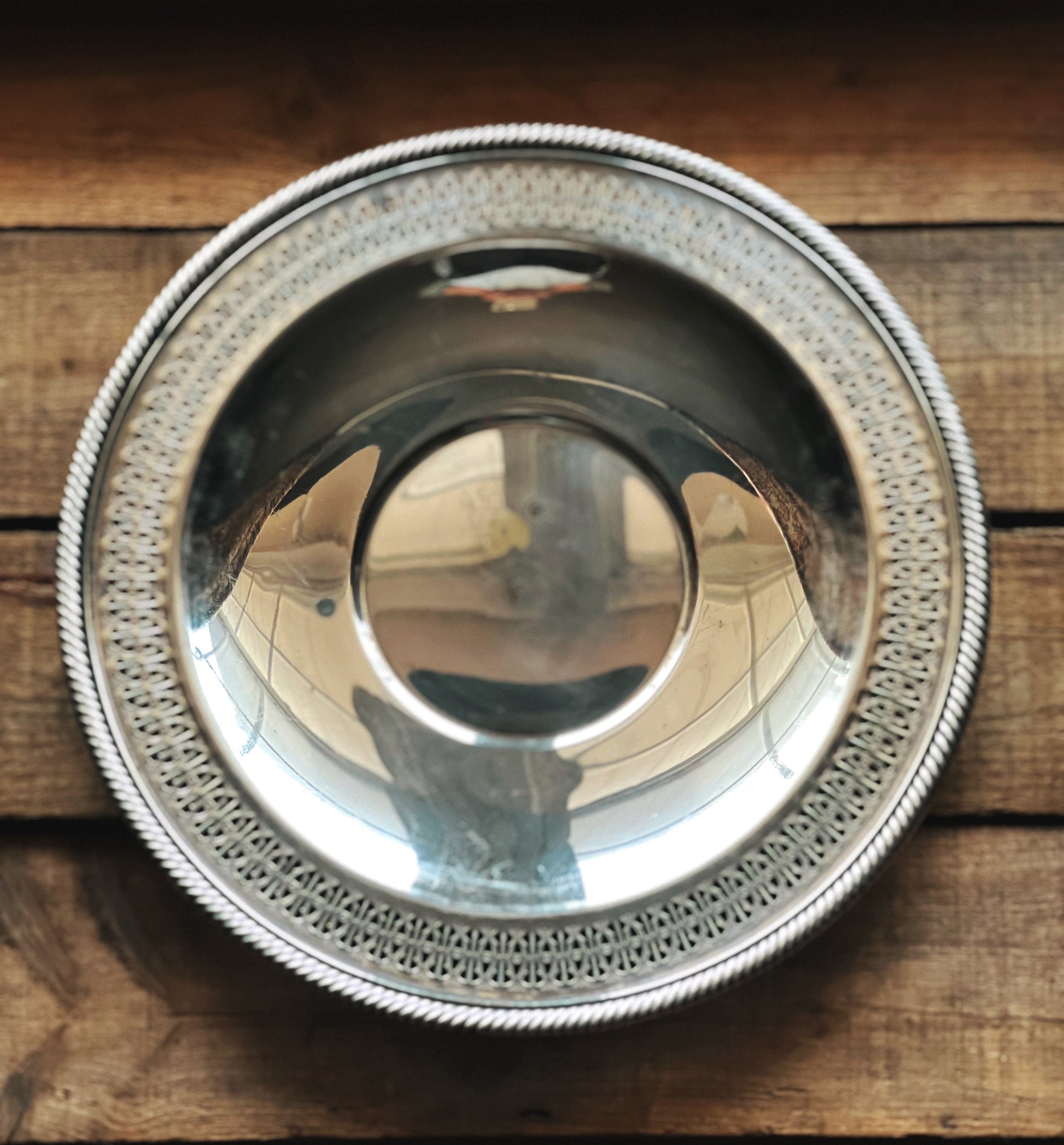 Silver bowl with intricate design on a wooden surface