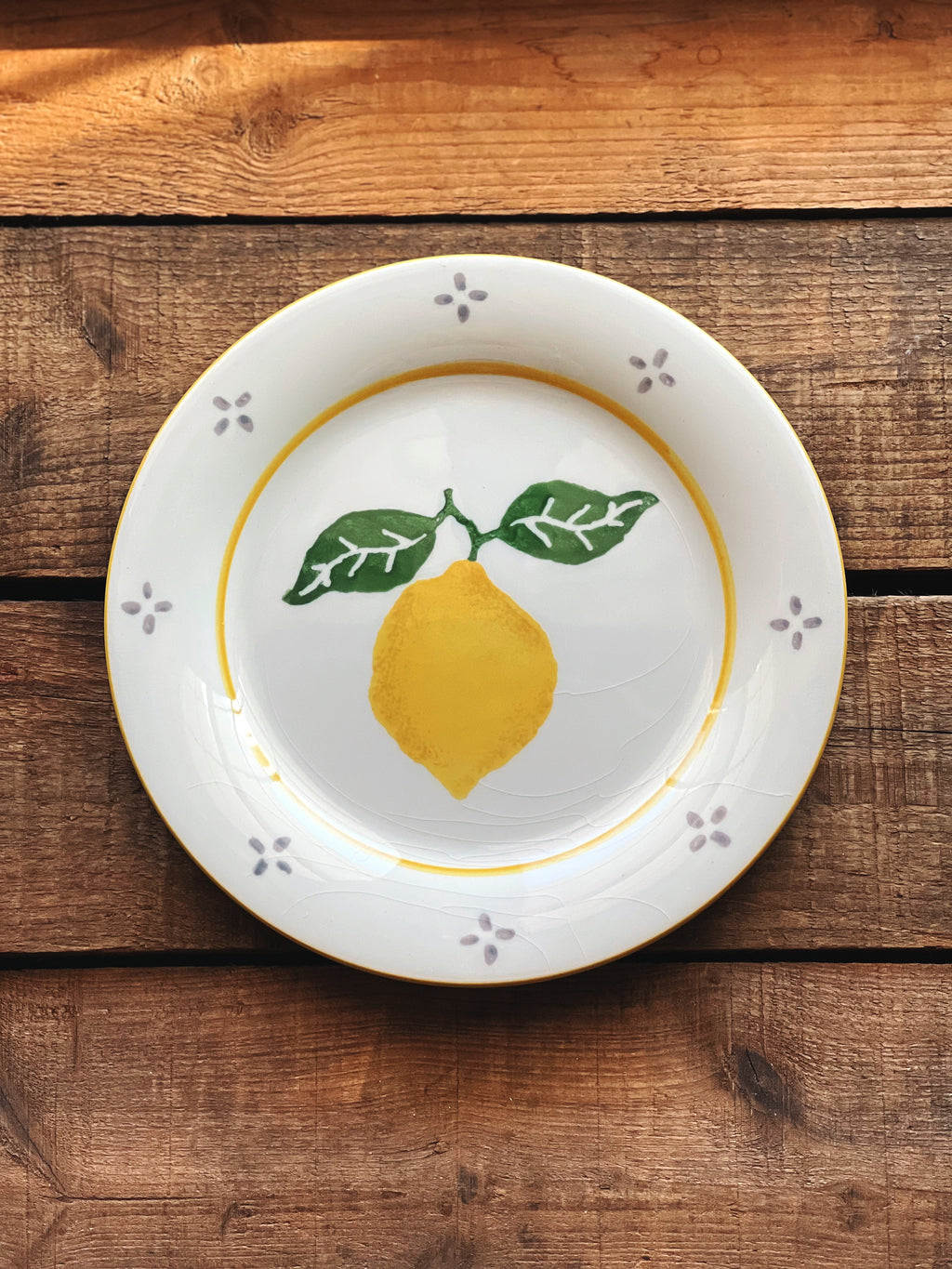 White plate with a lemon design on a wooden surface