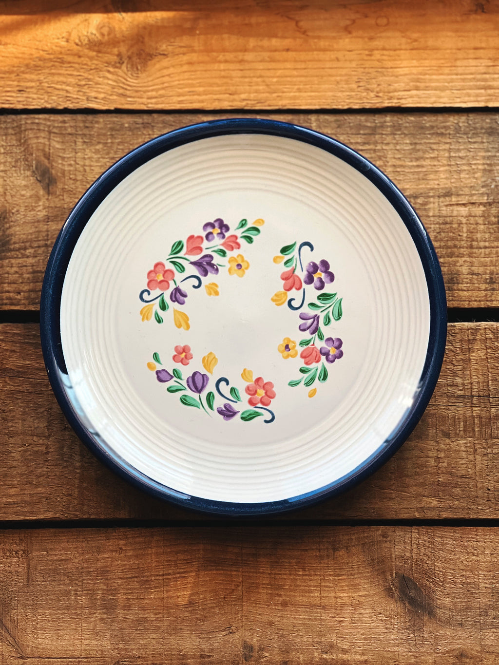 Decorative plate with floral design on a wooden surface