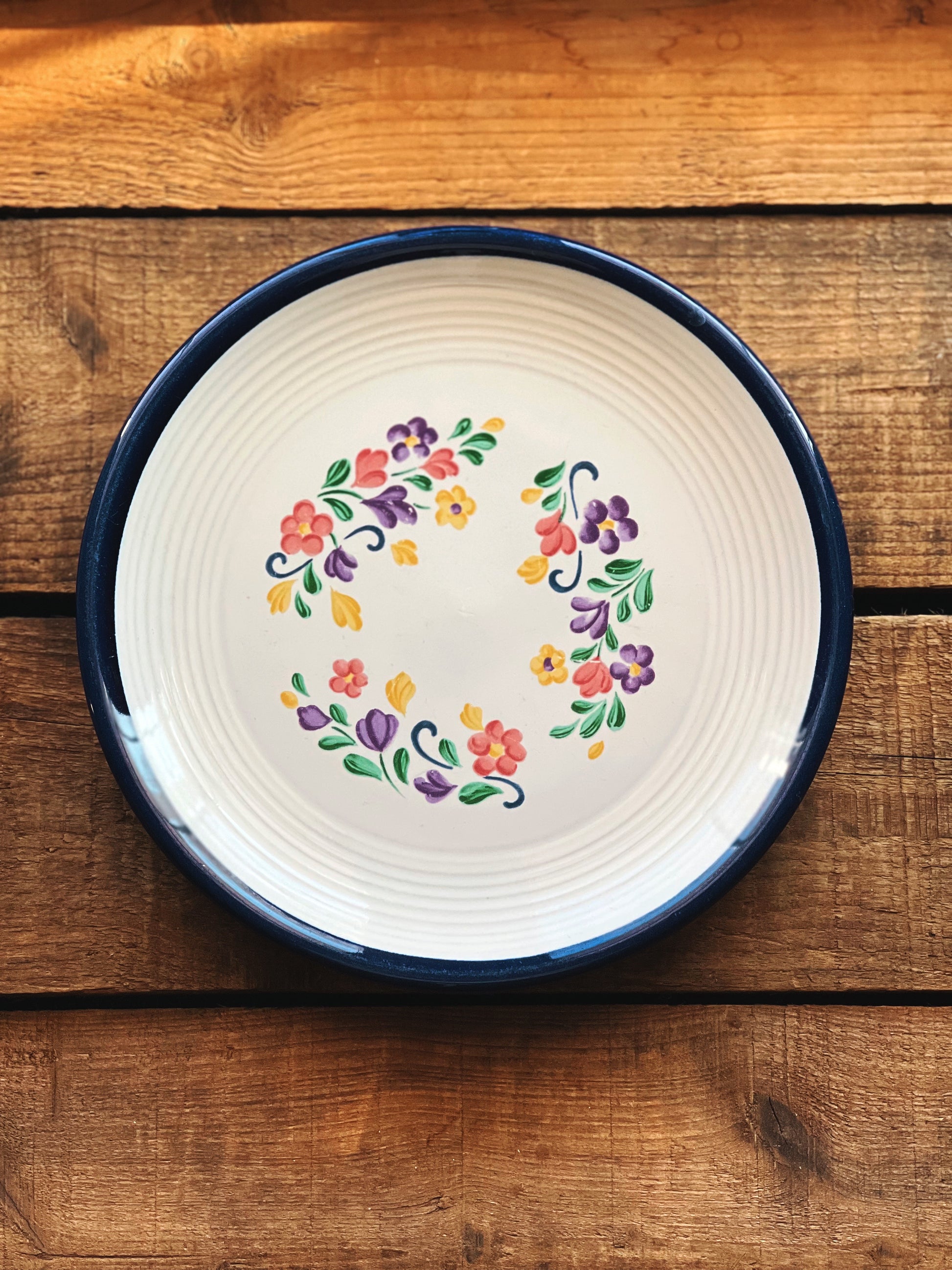 Decorative plate with floral design on a wooden surface