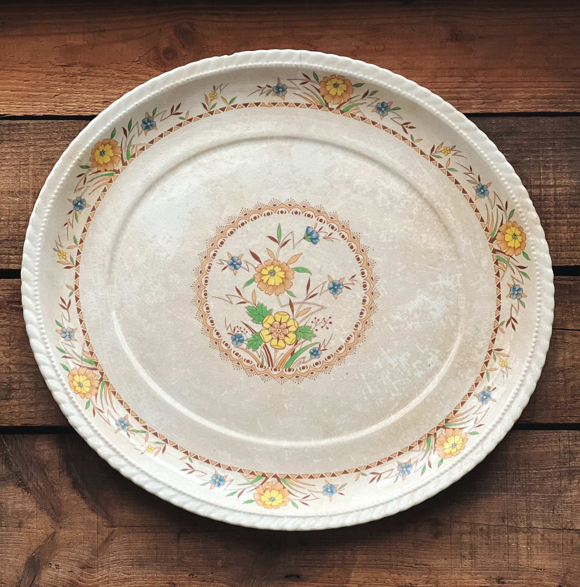 Decorative ceramic plate with floral patterns on a wooden surface