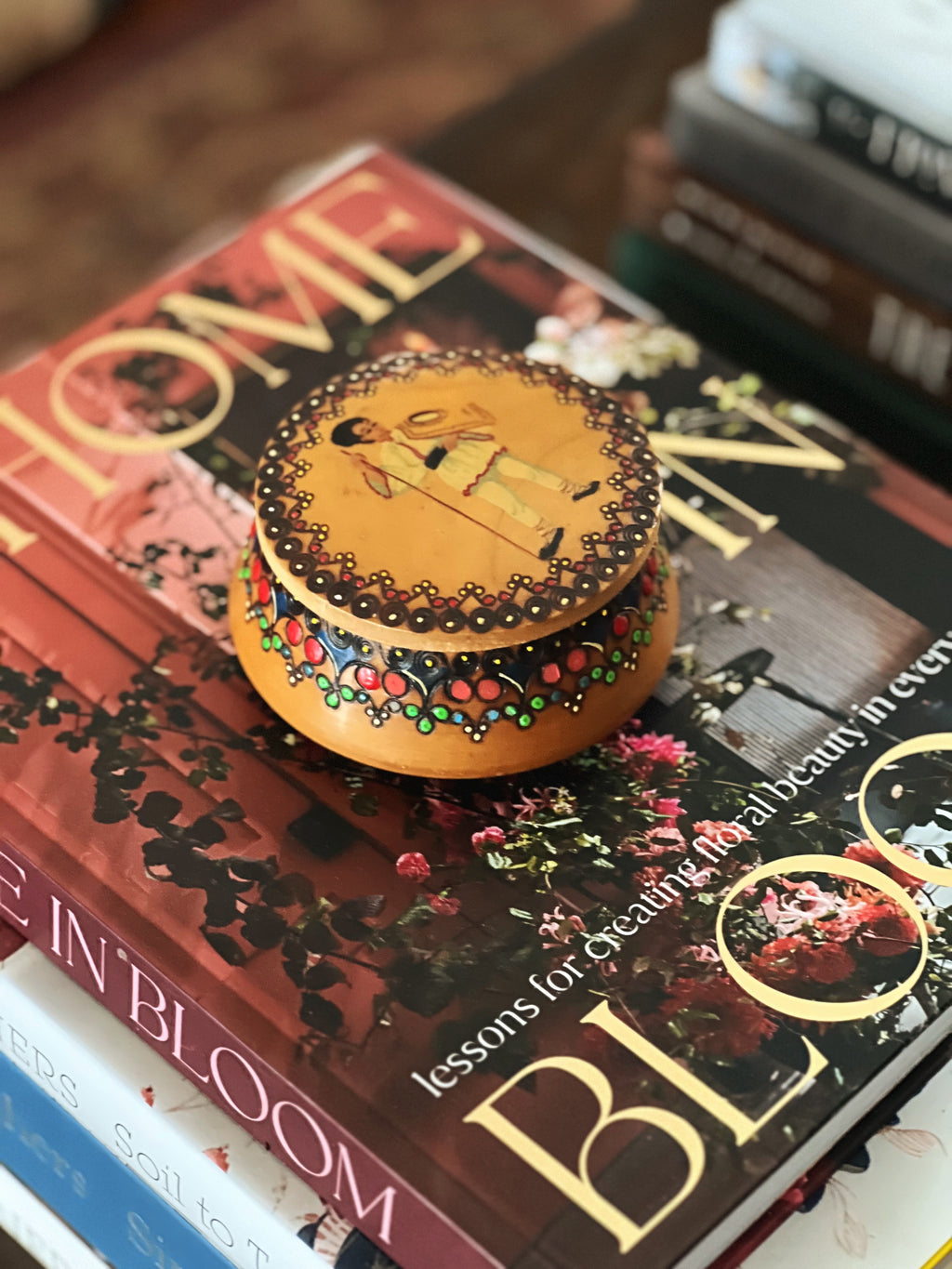 Decorative wooden box on a stack of books with visible text