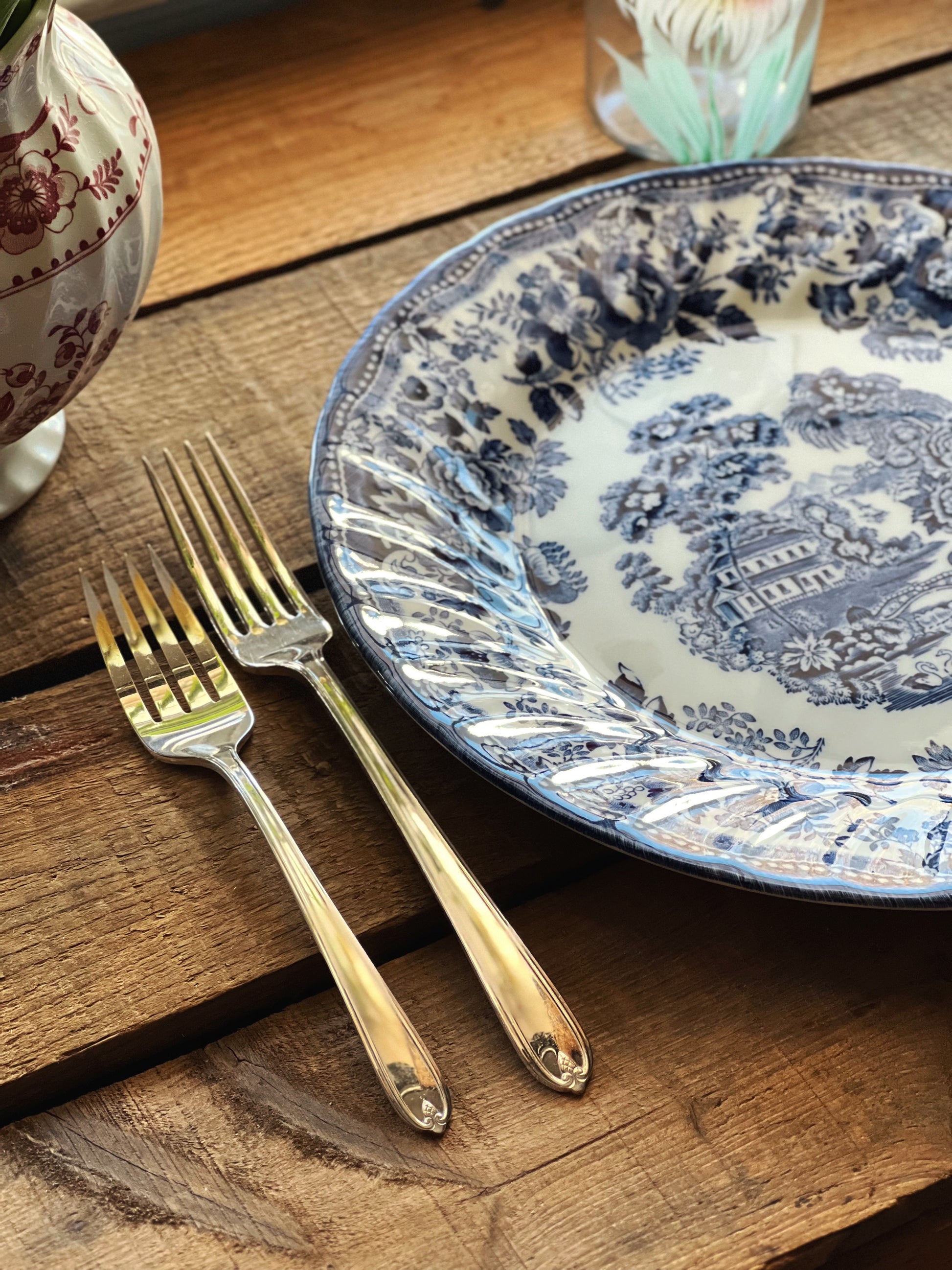 Silver fork and knife on a decorative blue and white plate on a wooden surface