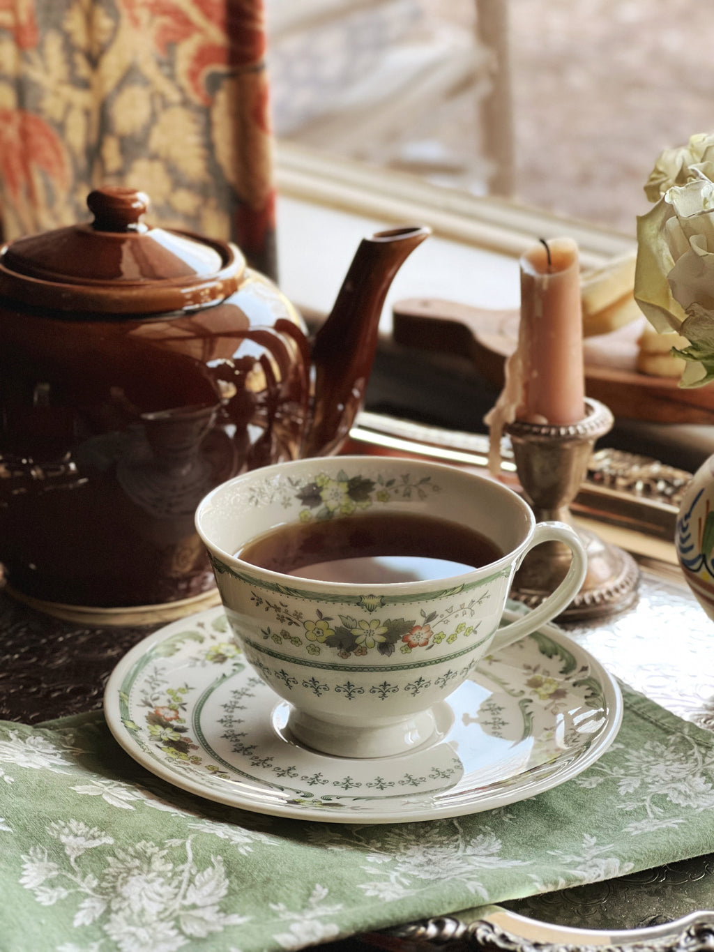 Collection of Royal Doulton Provencal tea cups and saucers arranged on a wooden table near a window