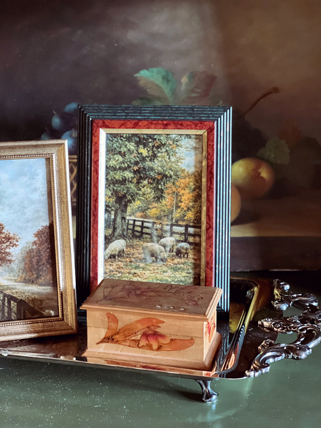 Decorative wooden box with framed artwork of sheep in a field on a reflective surface.