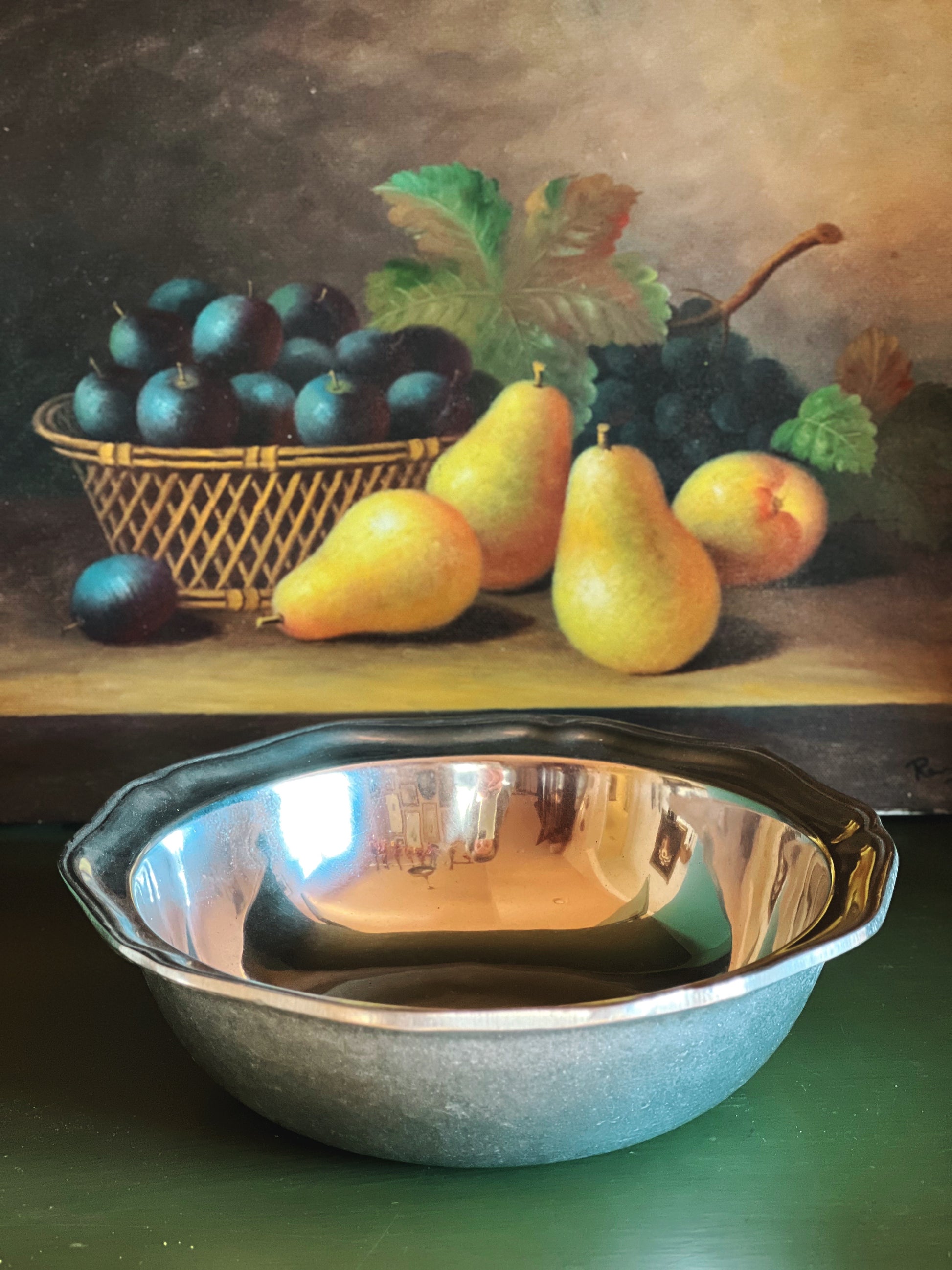 Still life painting of pears, plums, and a metal bowl on a wooden surface.