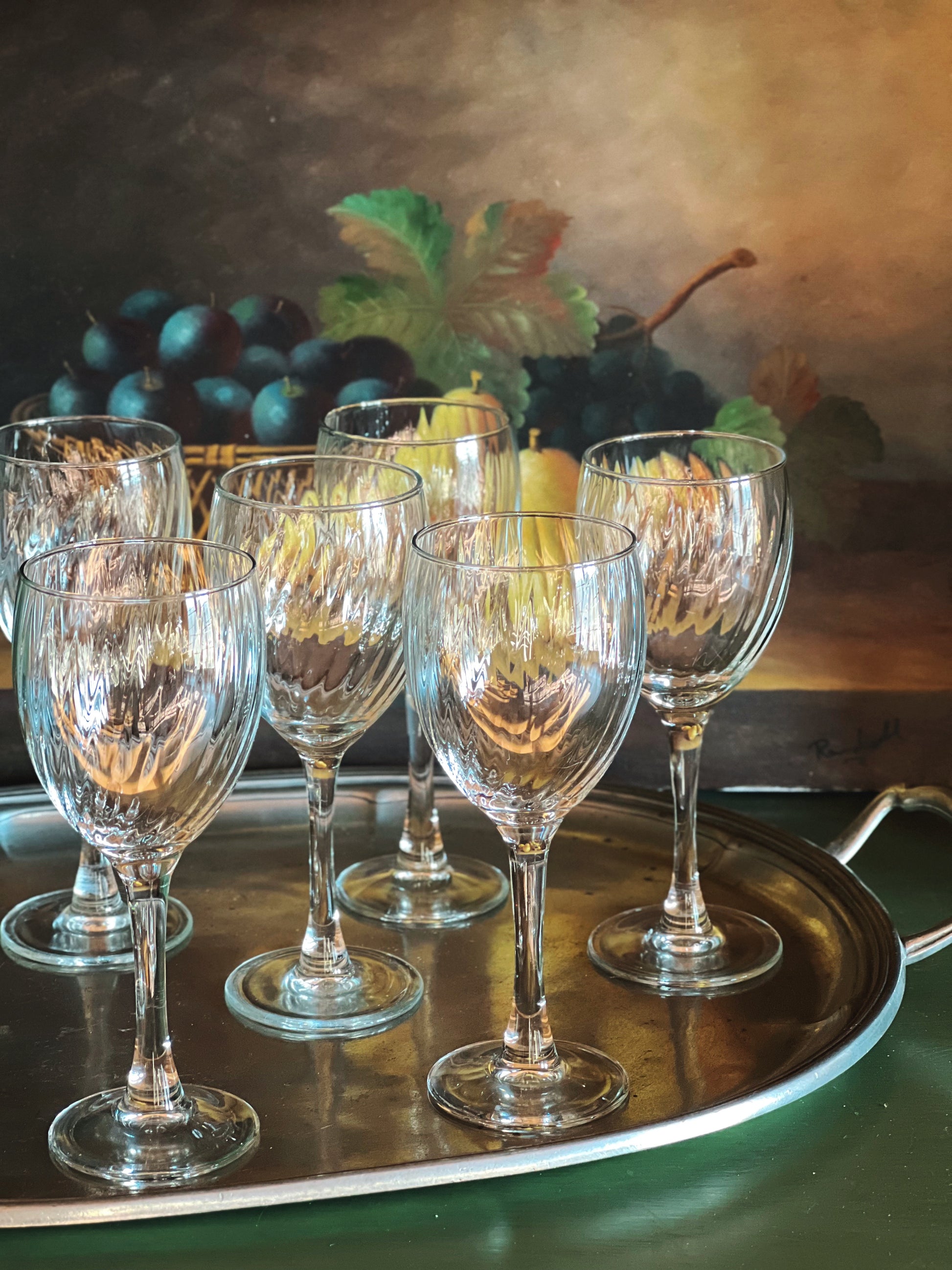 Set of clear wine glasses on a silver tray with a blurred background