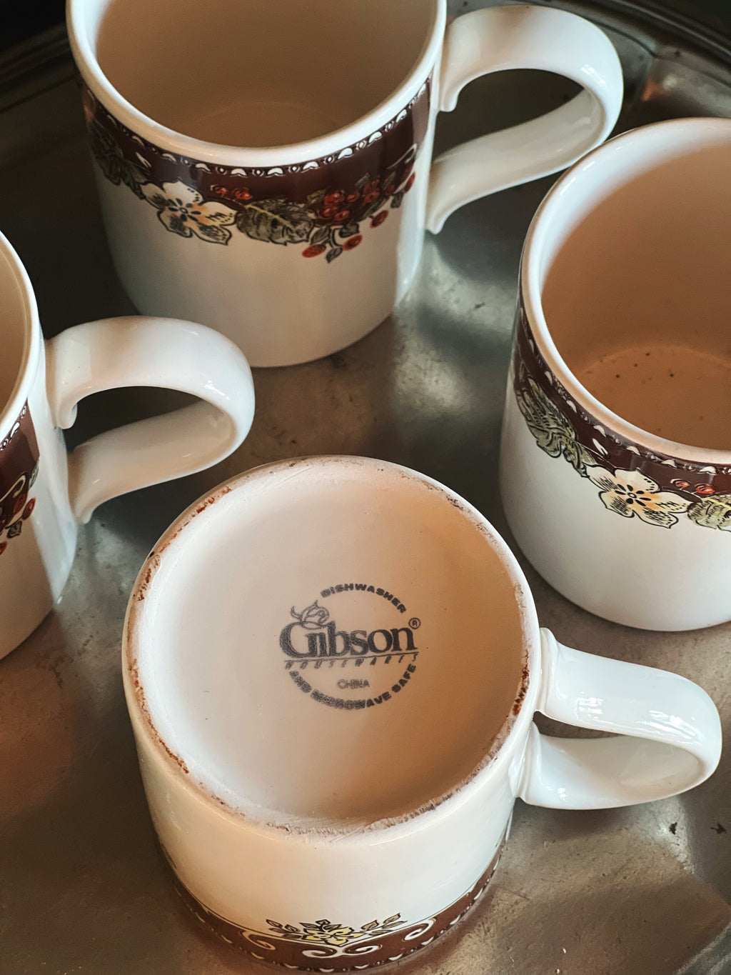 Set of Gibson coffee mugs on a metal surface